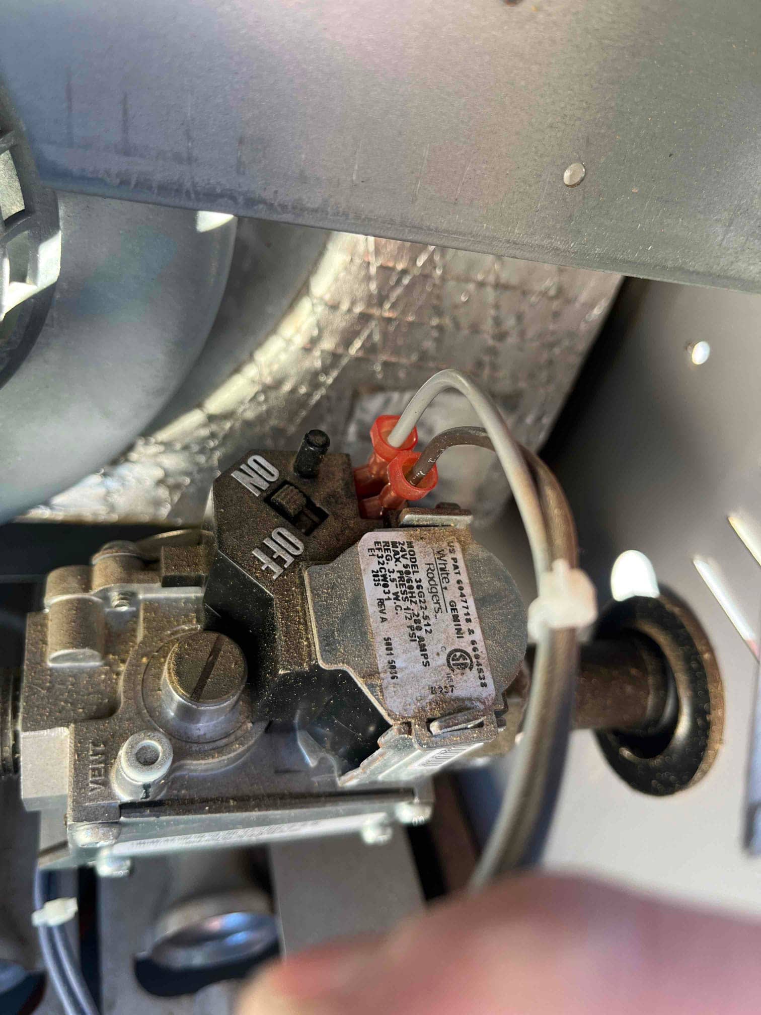 Furnace gas valve assembly with ON/OFF control knob, two white control wires, and outlet tube through grommet.