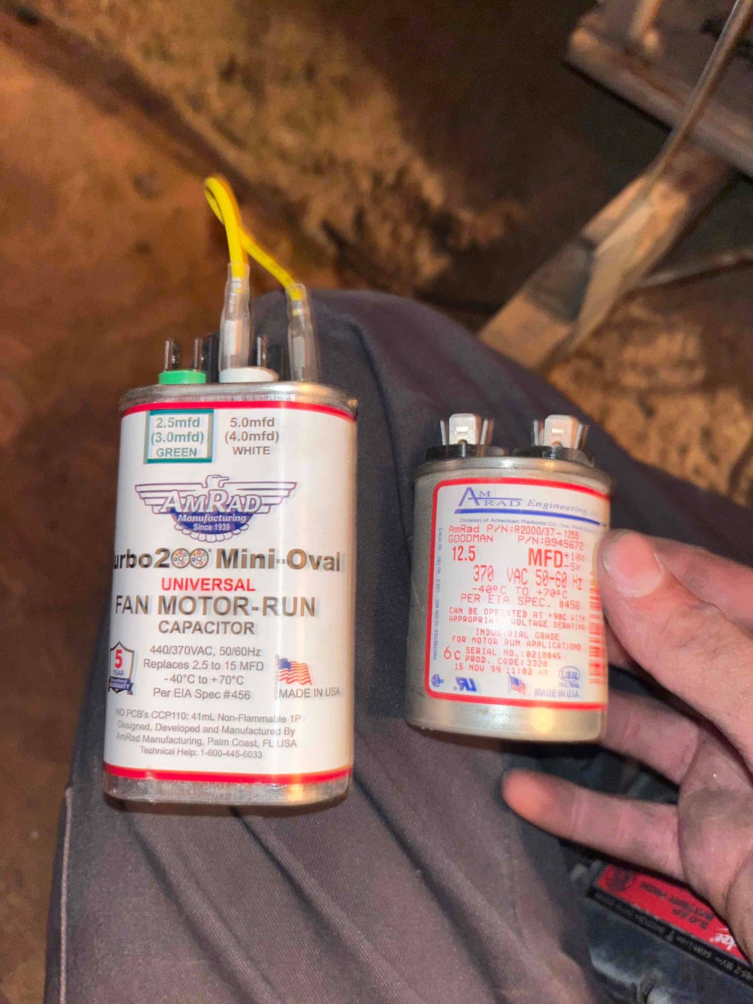 Two motor-run capacitors held in hand; left labeled 440/370VAC, replaces 2.5 to 15 MFD; right labeled 12.5 MFD, 370 VAC.
