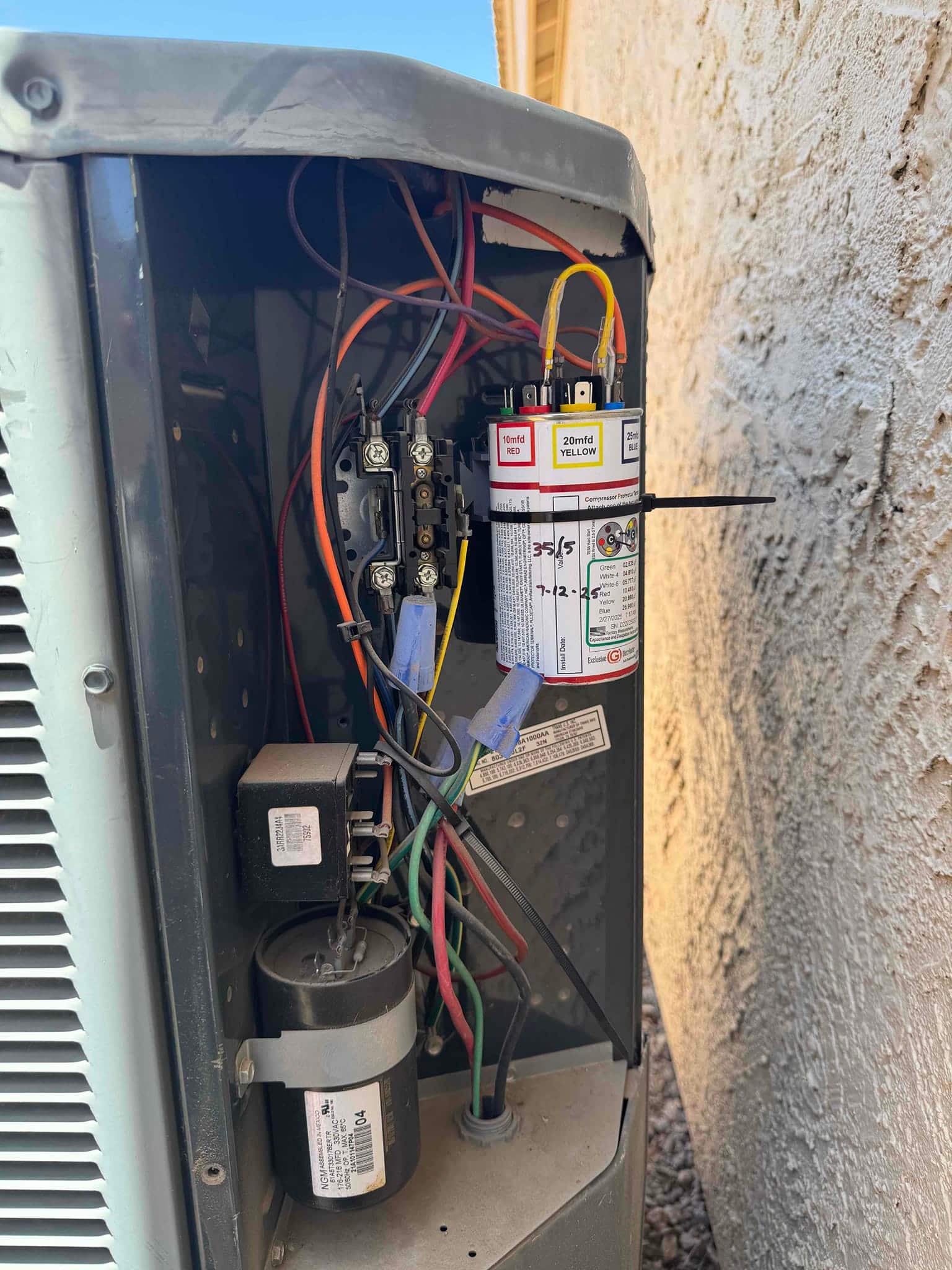 Outdoor condenser control compartment shows wiring, contactor, and a multi-tap capacitor labeled 10 mfd red, 20 mfd yellow, 20 mfd blue.