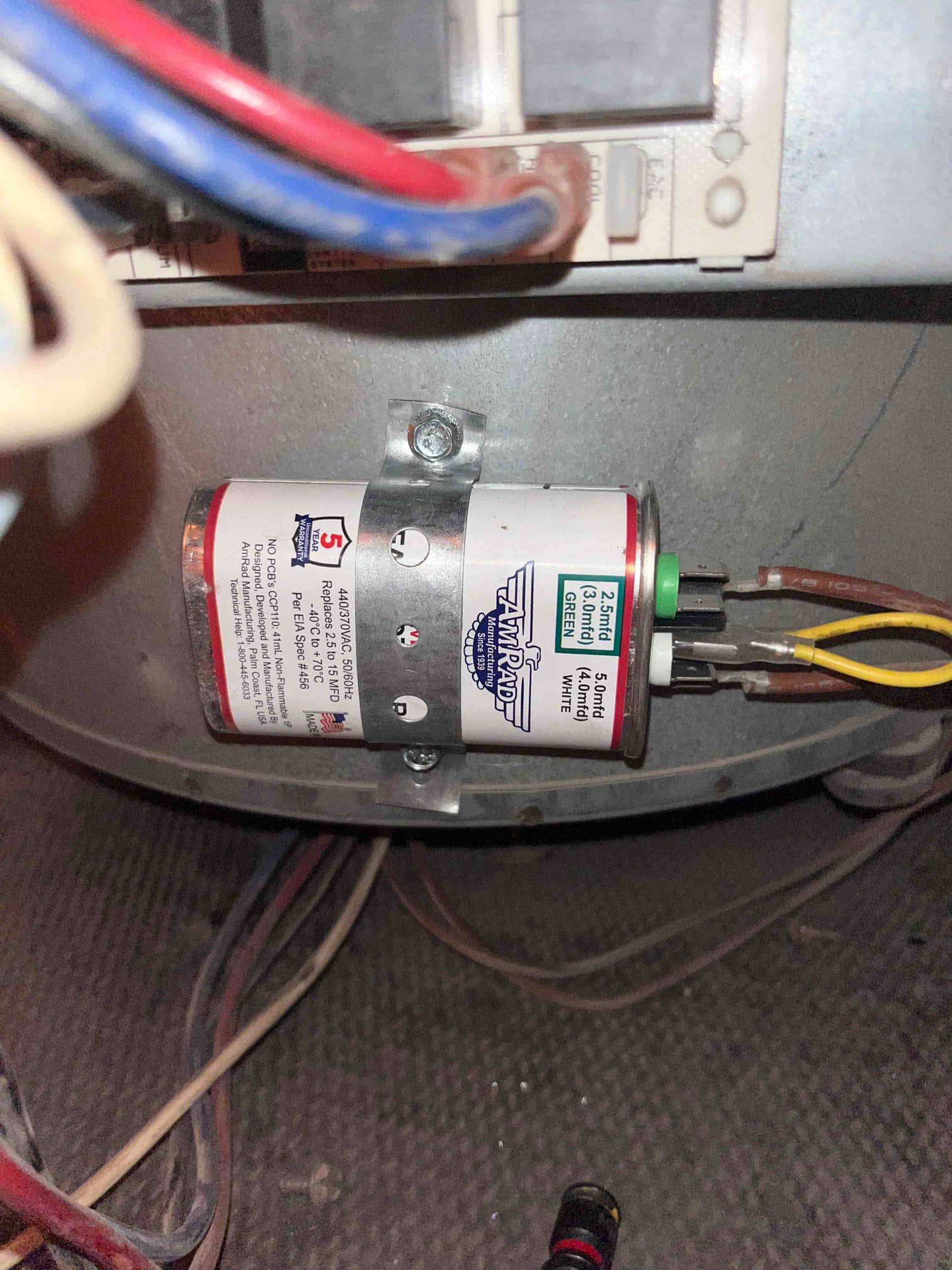 Run capacitor mounted with strap inside the unit, label shows 5 MFD rating with yellow and brown wires connected.