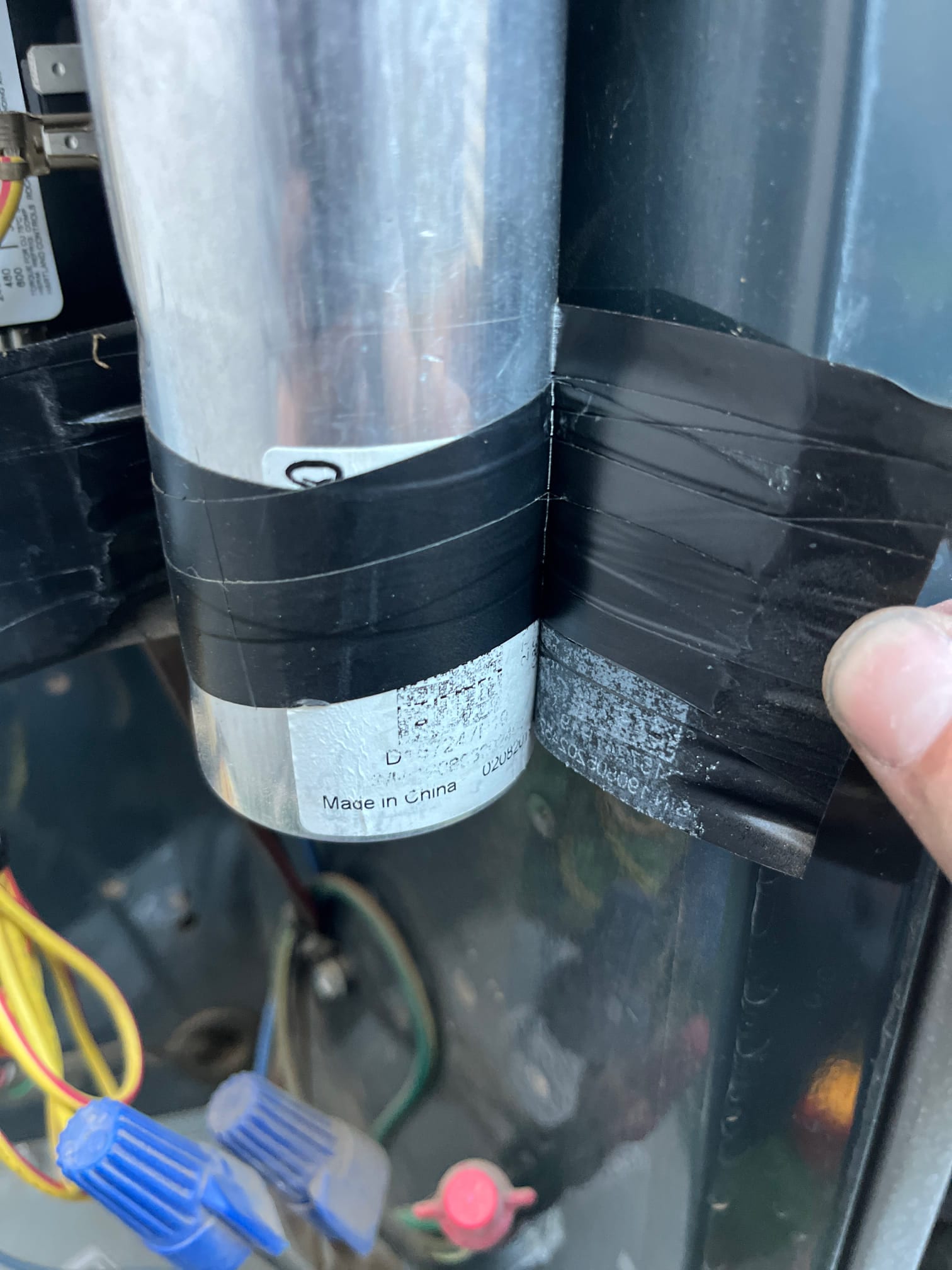 Run capacitor secured with black tape inside condenser panel, with connected yellow and brown wiring and wire nuts.