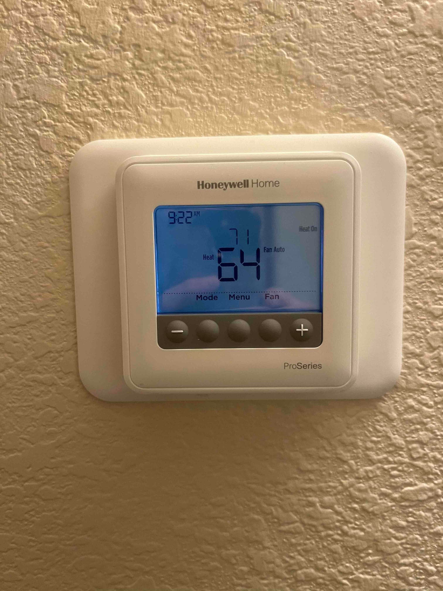 Wall-mounted thermostat display shows heat mode active with a 64°F room temperature and 71°F setpoint.