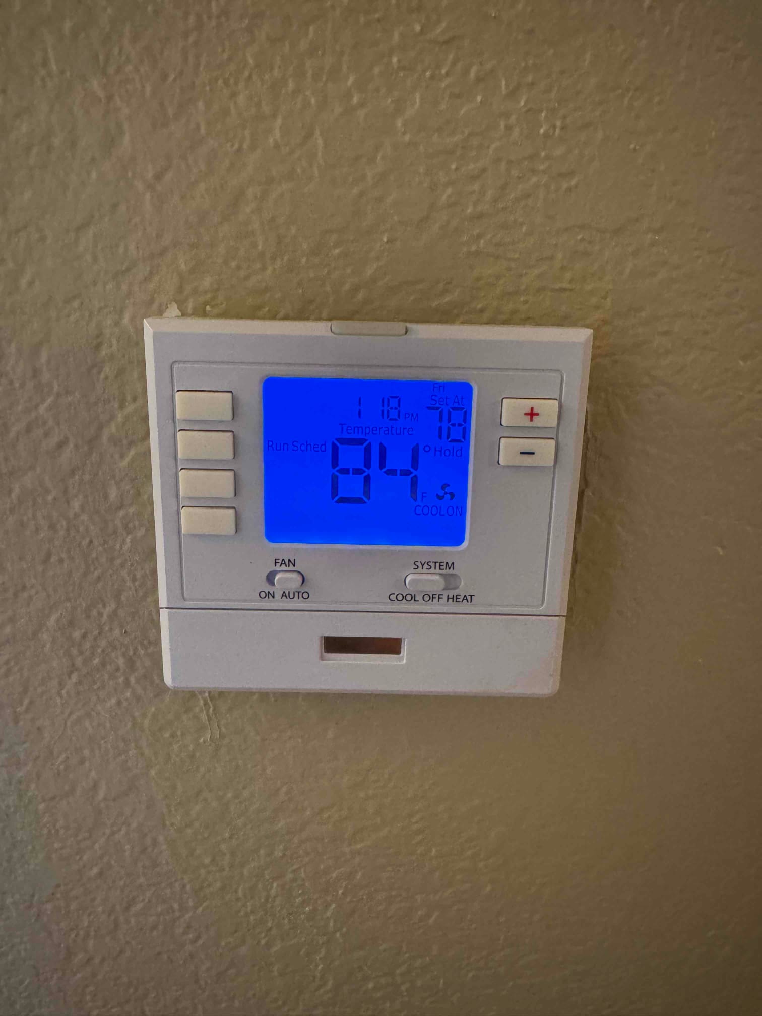 Wall-mounted thermostat displays 84°F indoor temperature, cooling mode on, with fan auto and system set to cool.