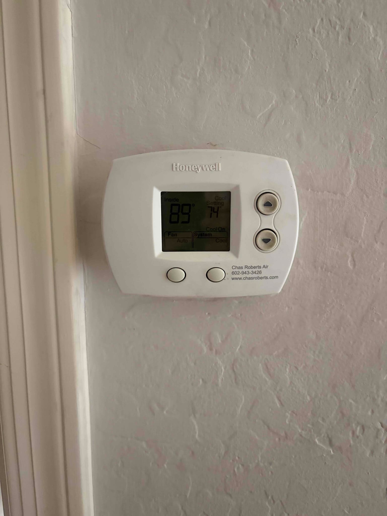 Wall-mounted thermostat displays 89°F inside with cooling set to 74°F, buttons and mode indicators visible.