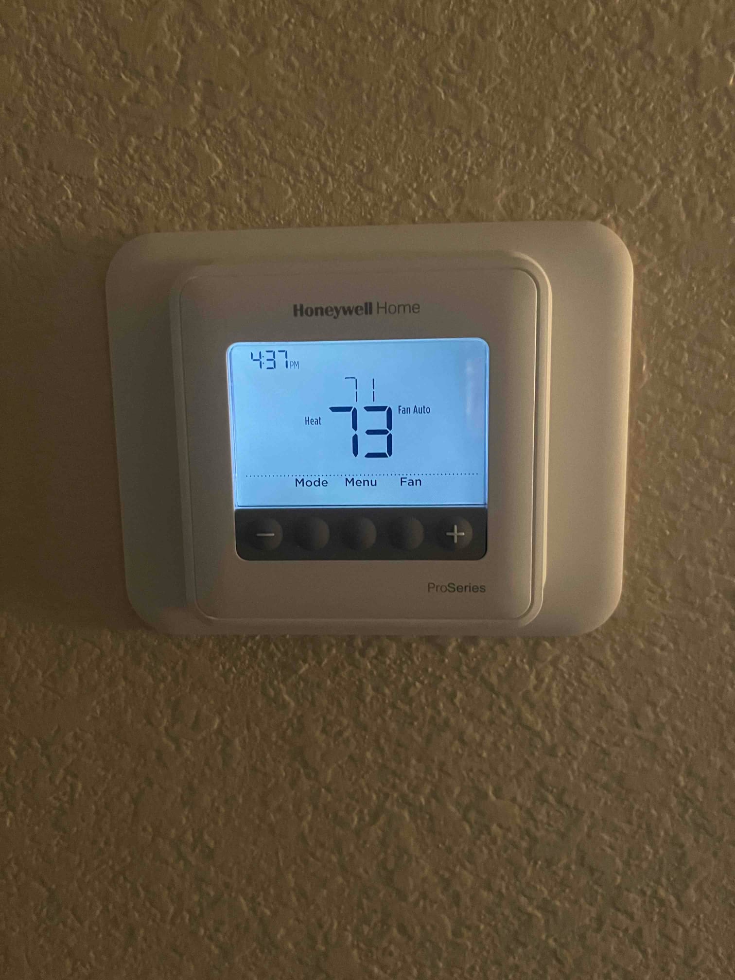Wall-mounted thermostat shows indoor temperature 73, heat mode selected, setpoint 71, and fan set to Auto.