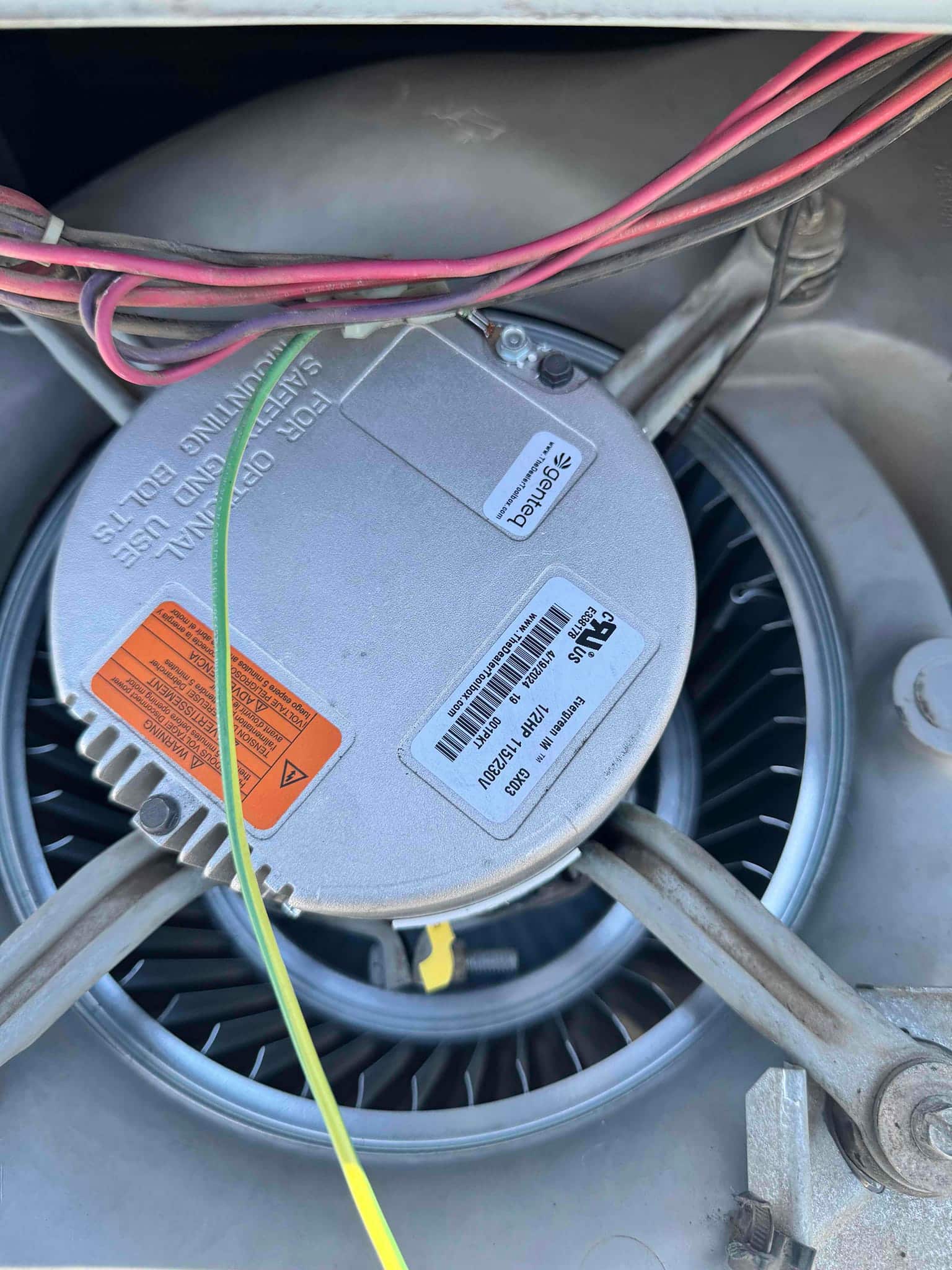 Blower motor and wheel assembly with wiring harness visible at the top, showing mounting brackets and connected leads.