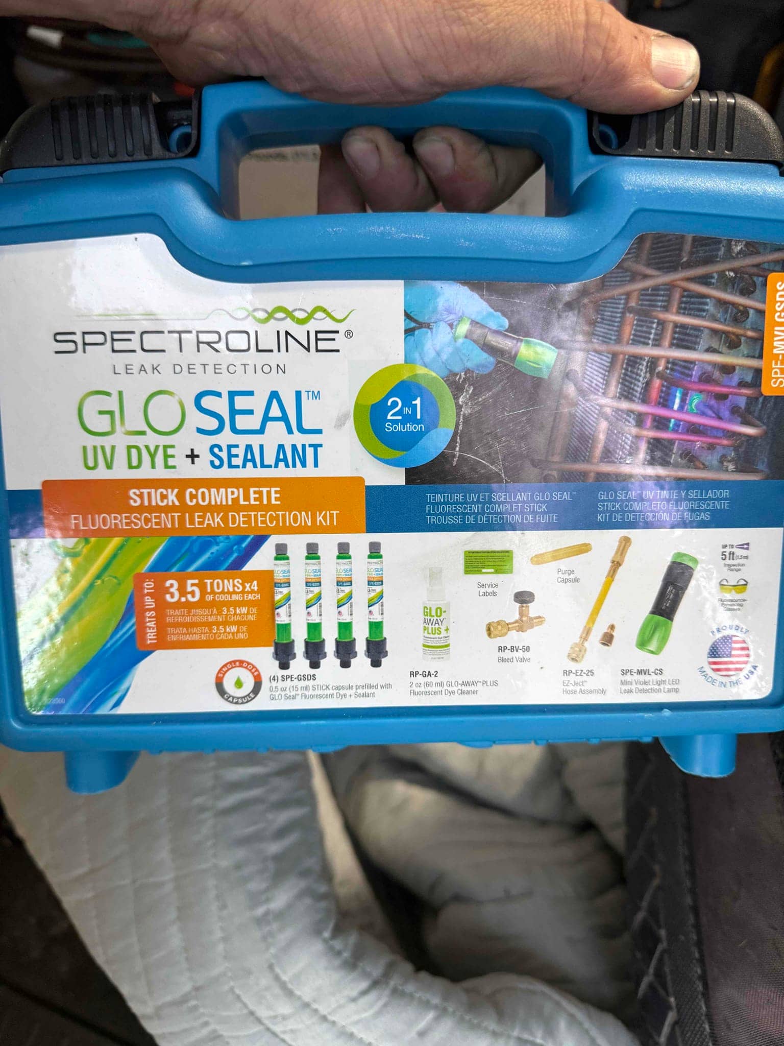 Blue carrying case for a UV dye and sealant leak detection kit, shown with contents illustrations on label.