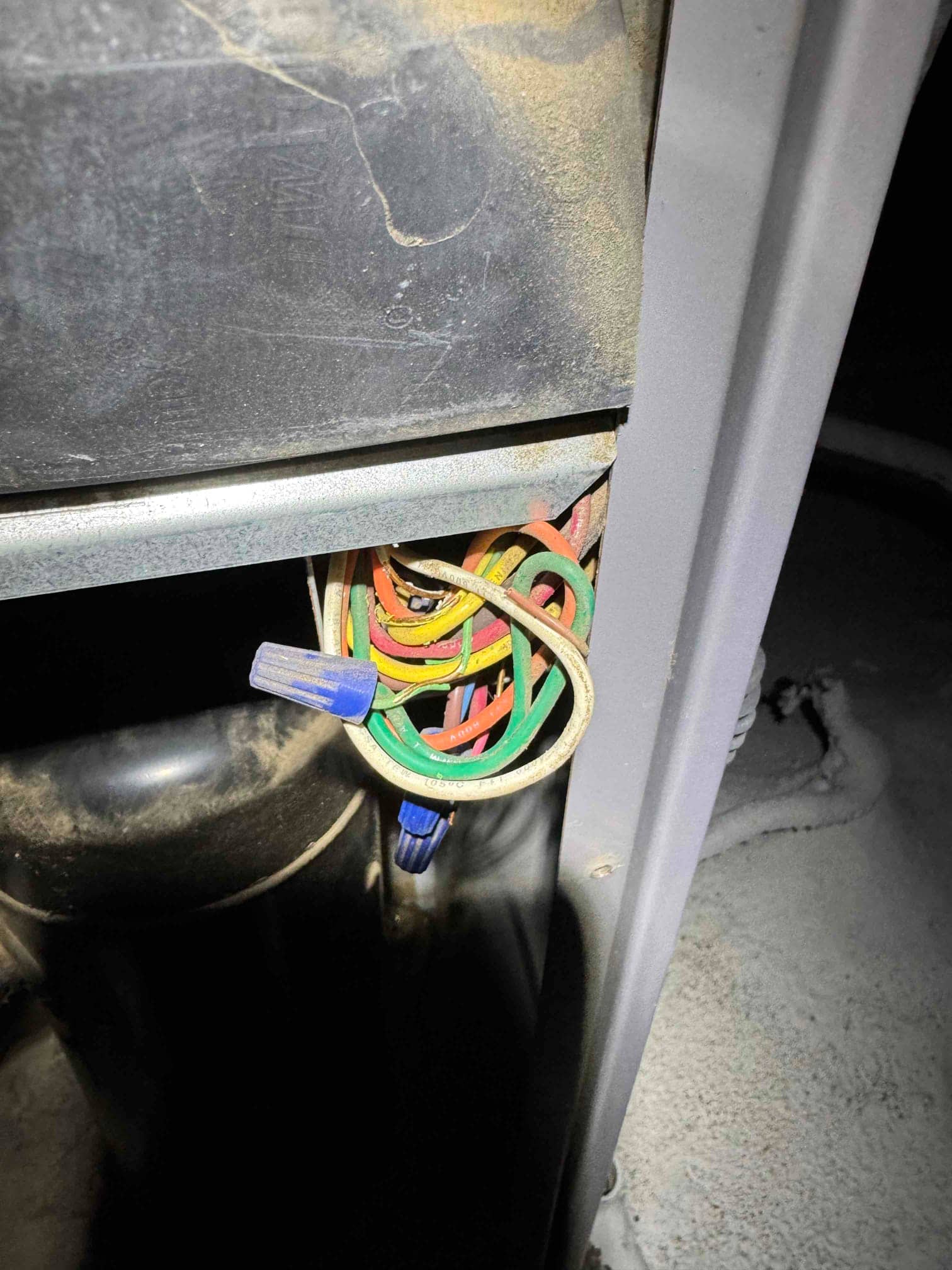 Bundled control wires with blue wire nuts inside the HVAC cabinet.