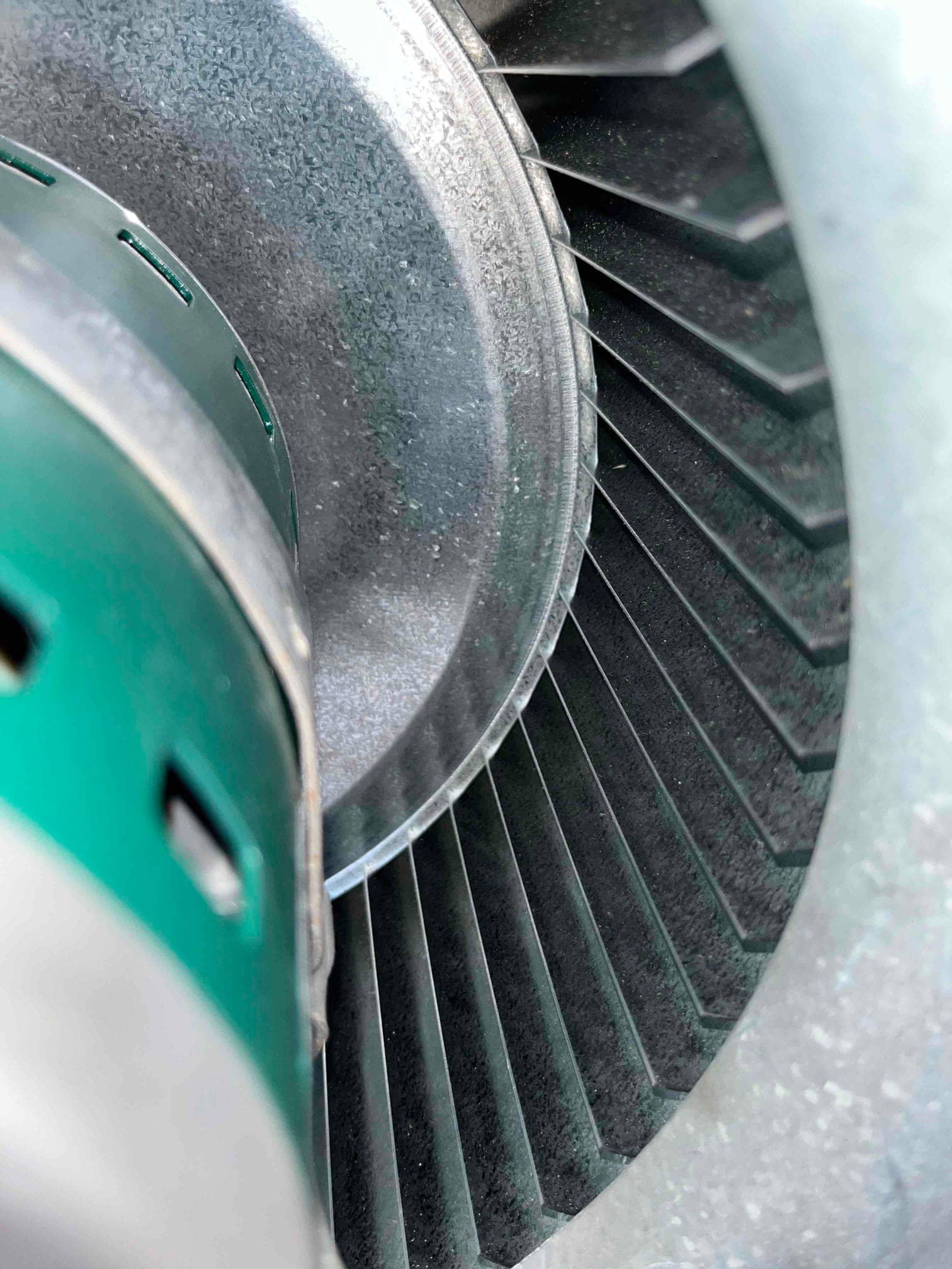 Centrifugal blower wheel with dust accumulation on the fins next to the motor housing.