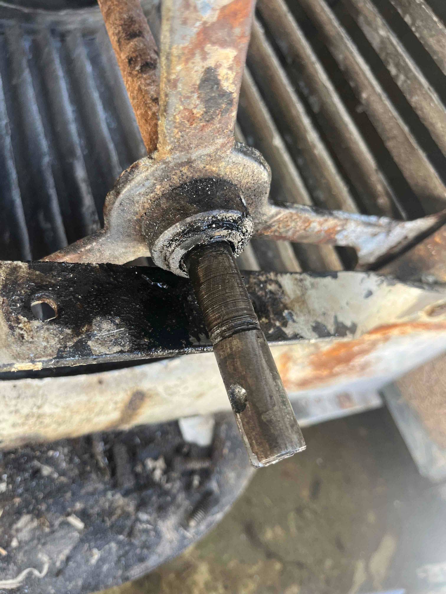 Close-up of condenser fan blade hub and motor shaft showing heavy rust and corrosion.