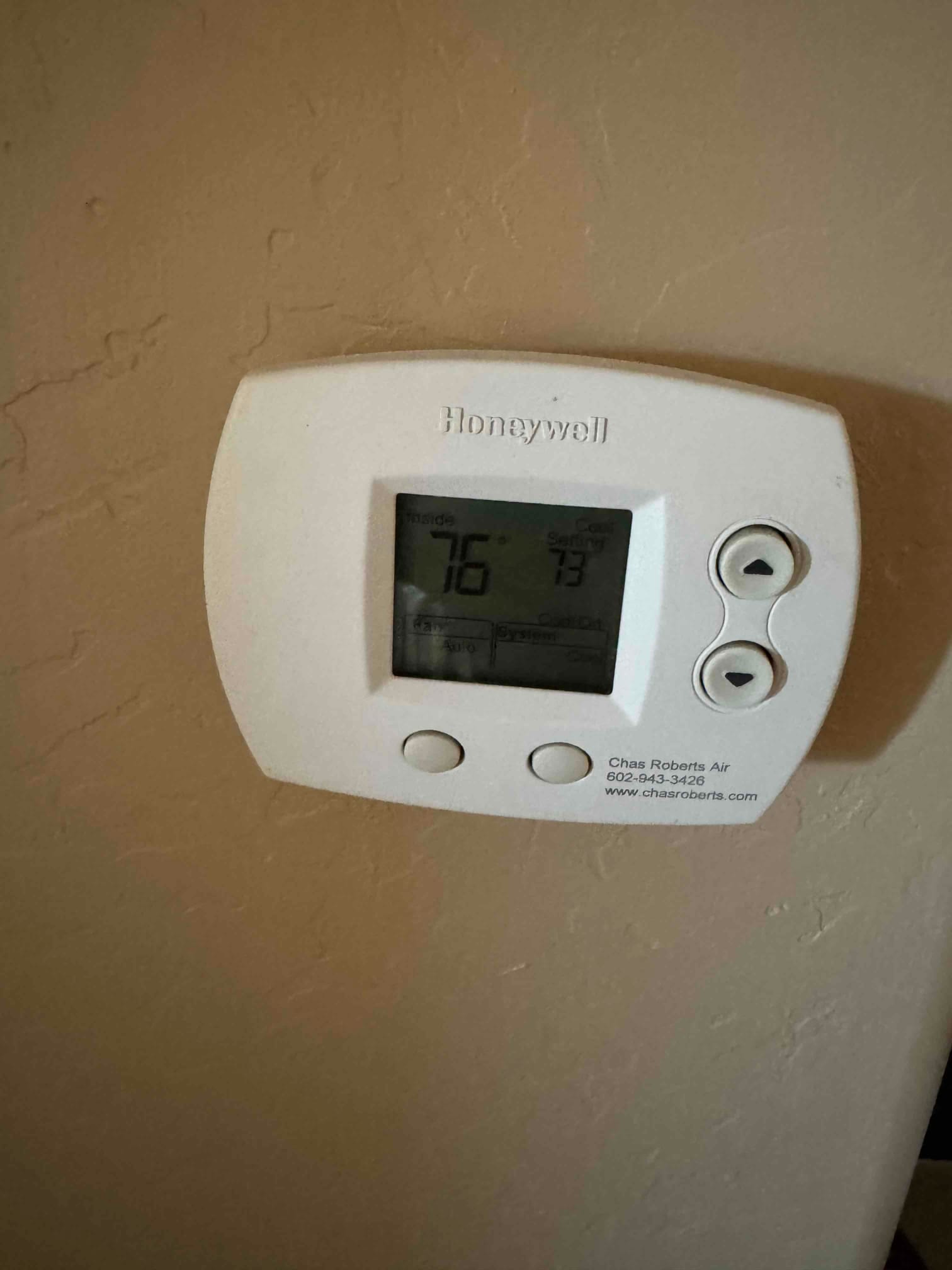 Digital thermostat on interior wall shows 76°F inside and cooling set to 73°F.