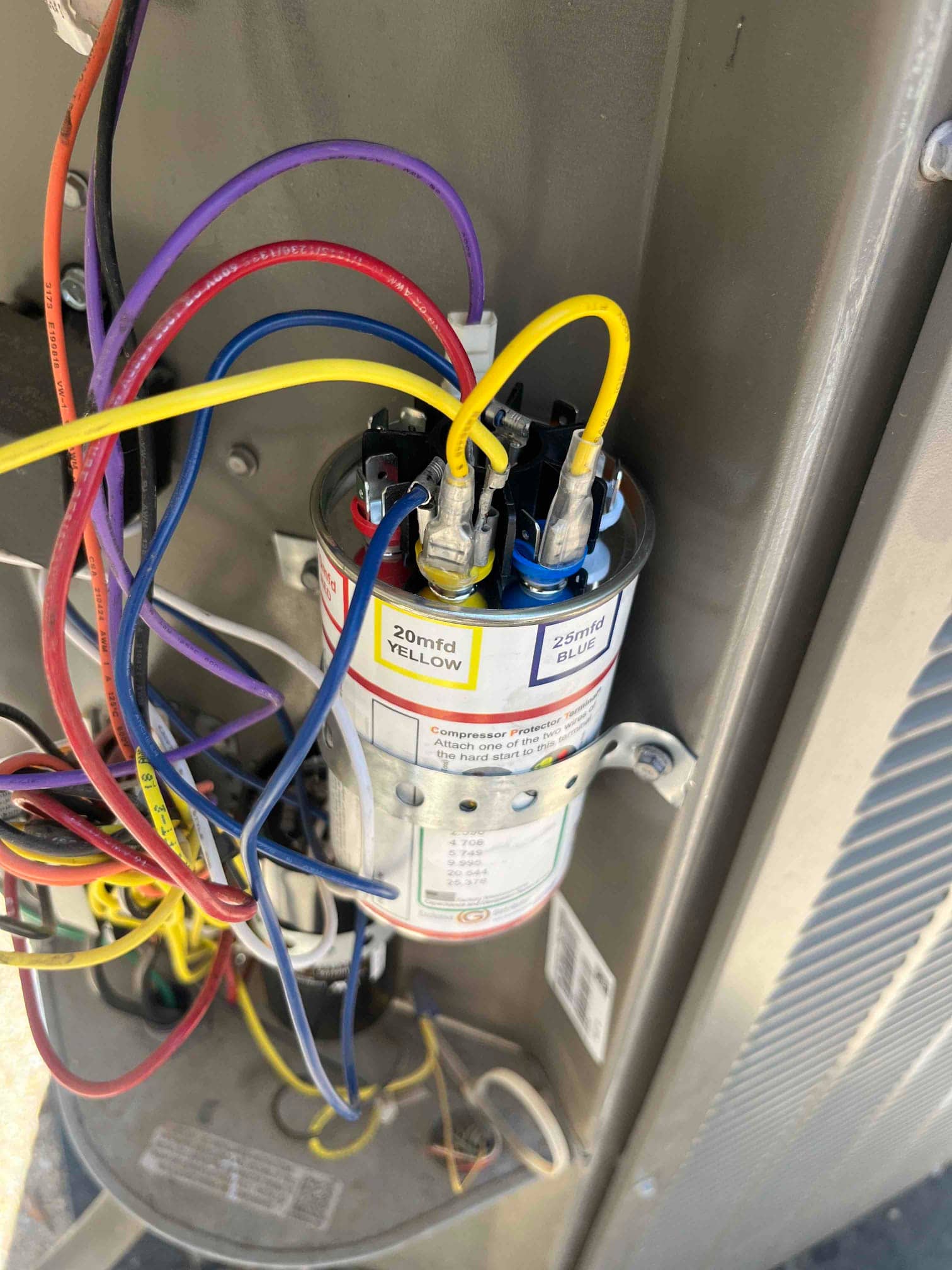 Dual-run capacitor with connected wiring, labels reading 20 mfd YELLOW and 25 mfd BLUE.