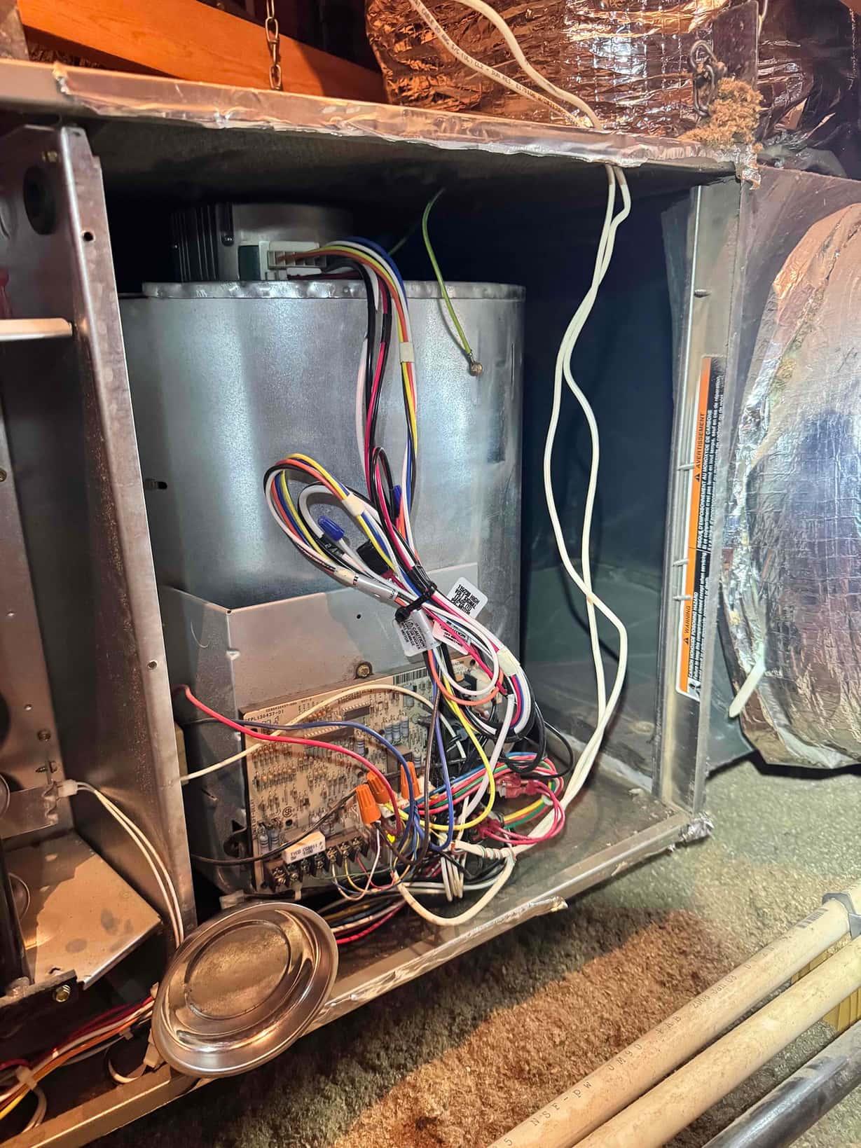ECM blower motor and control board with wiring exposed inside the air handler compartment.