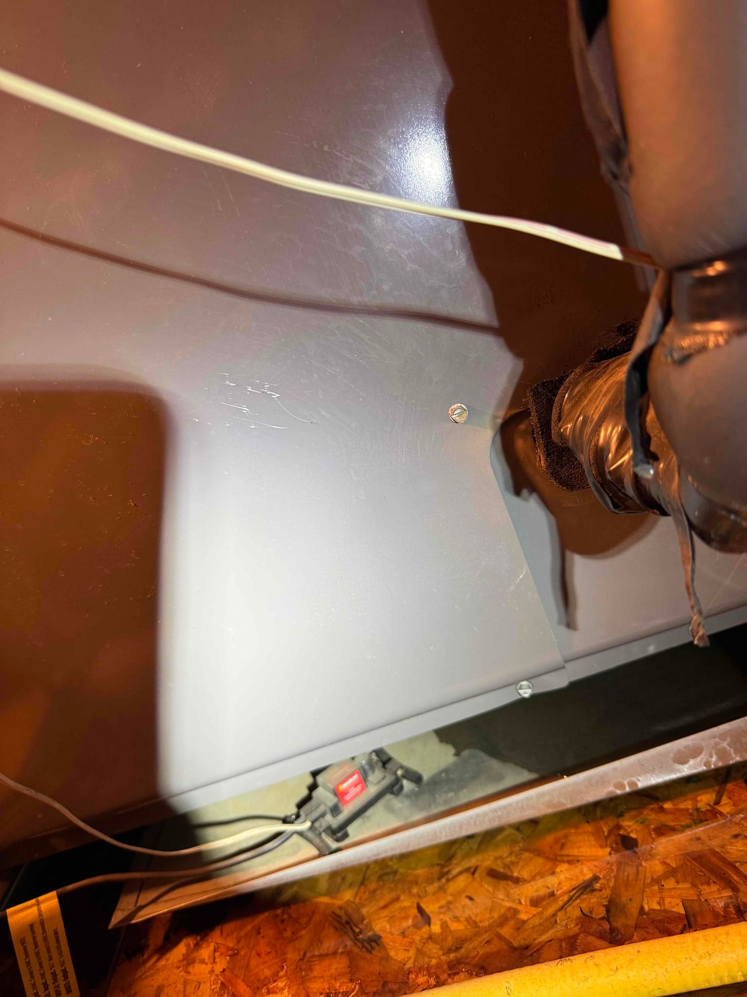 Inline condensate float safety switch sits in the drain pan beneath the air handler cabinet.