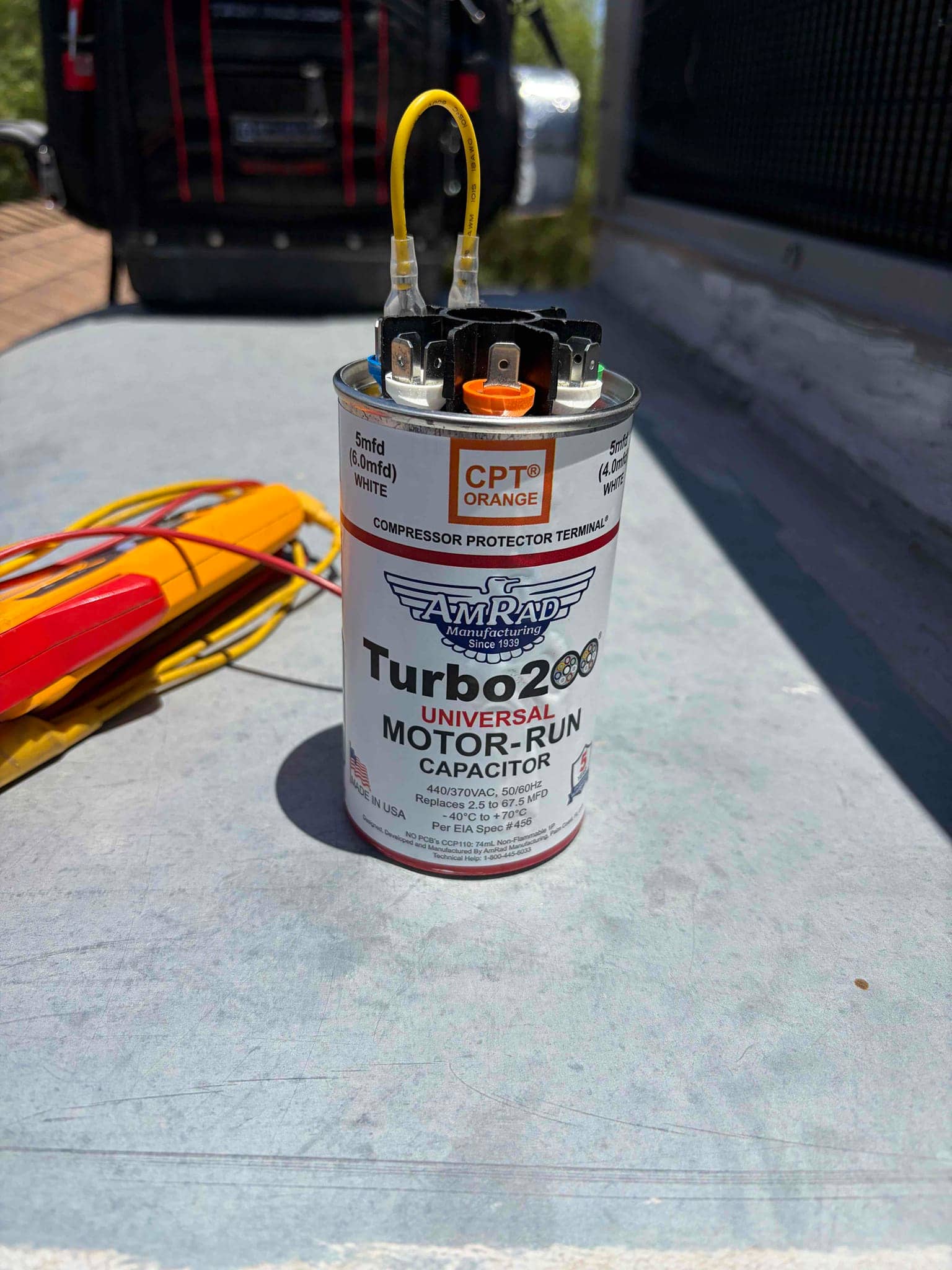 Motor-run capacitor with wiring terminals and yellow leads, labeled 440/370VAC and −40°C to +70°C.