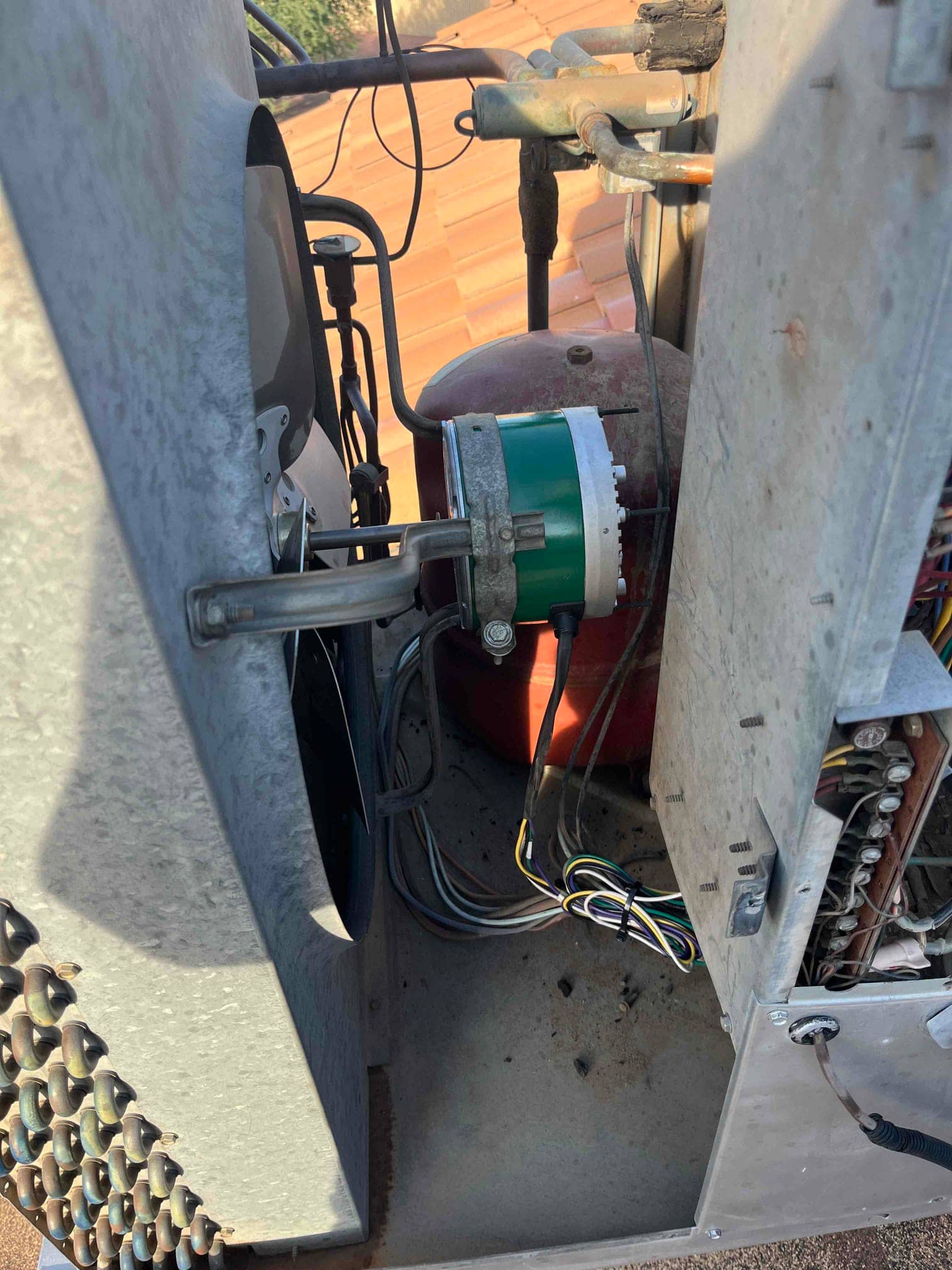 Open unit cabinet showing copper refrigerant lines, wiring harness, and internal components, with tubing connections and exposed metal housing.
