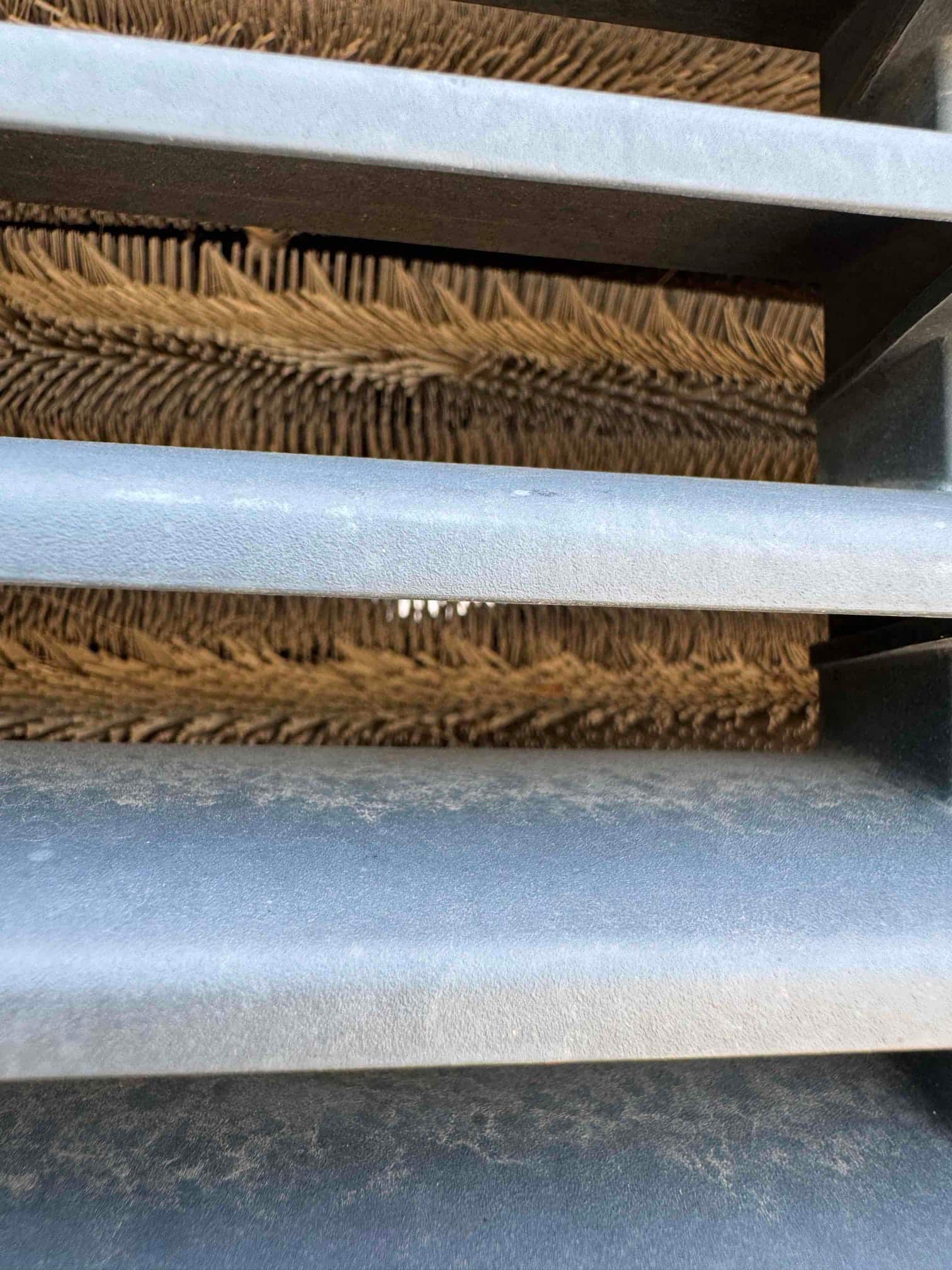 Outdoor condenser coil fins are visible behind the louvered grille, showing multiple bent areas along the fin surface.