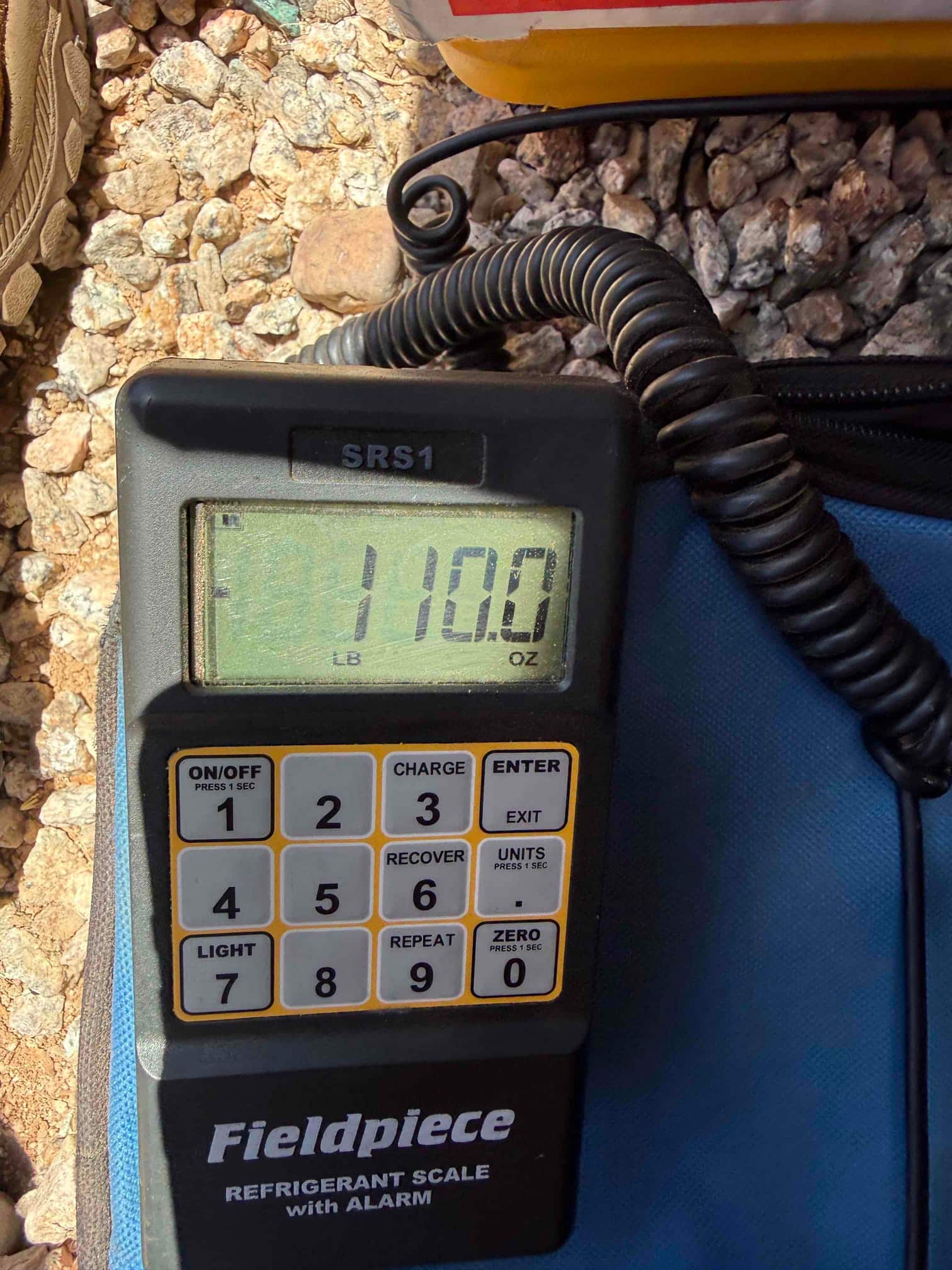 Refrigerant scale photographed during the service visit; no numerical reading is transcribed.
