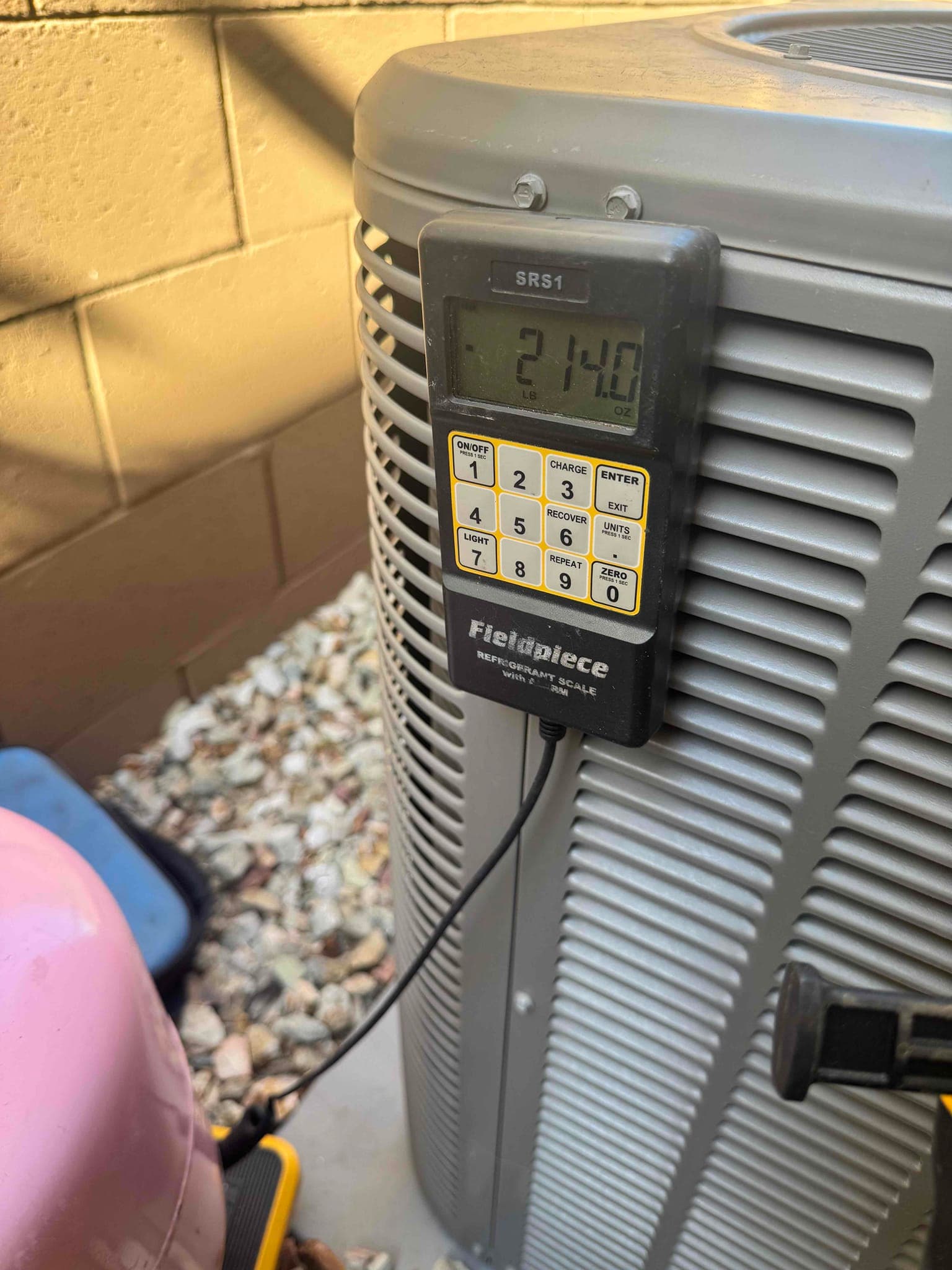 Refrigerant scale photographed during the service visit; no numerical reading is transcribed.