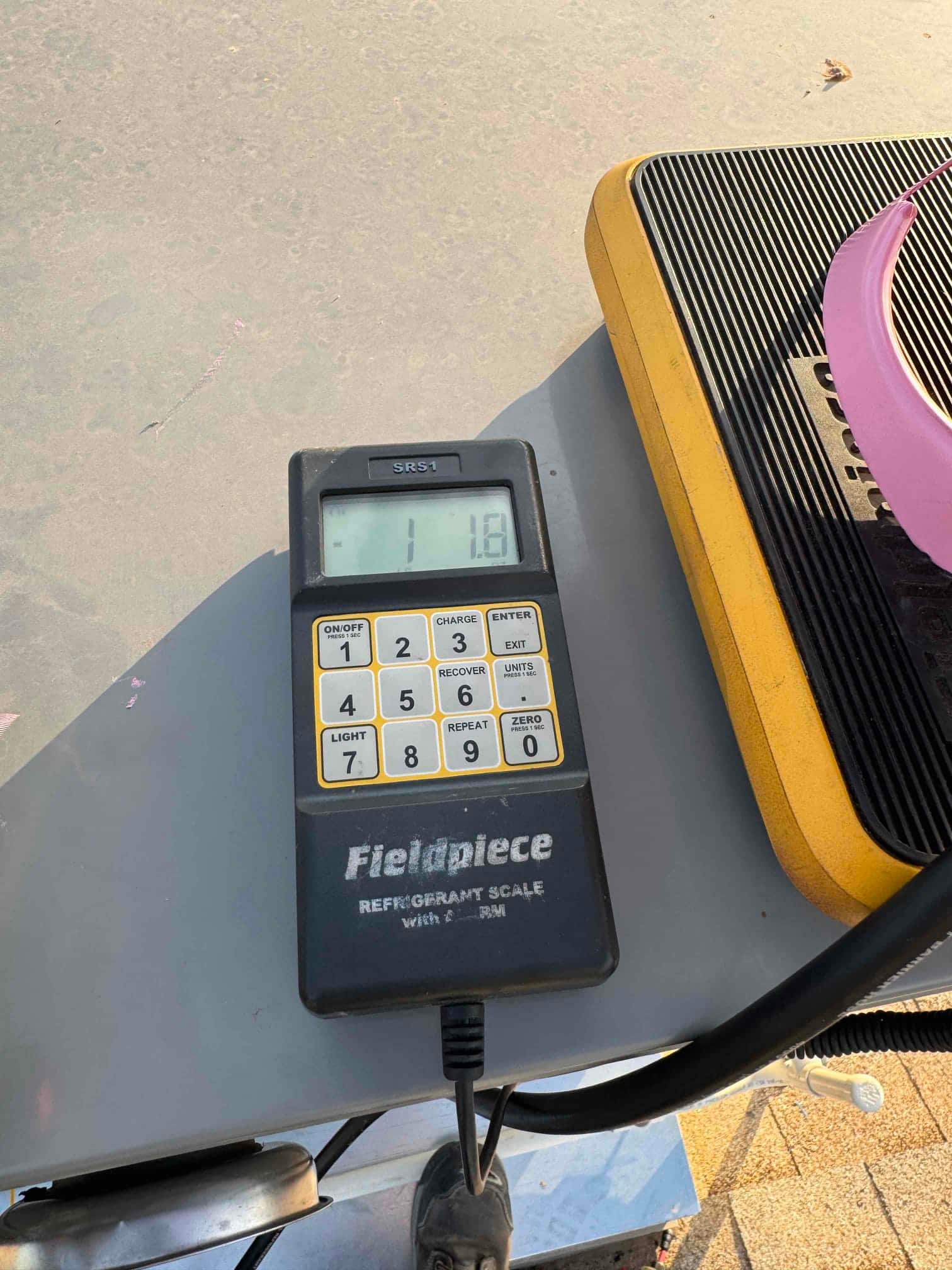 Refrigerant scale photographed during the service visit; no numerical reading is transcribed.