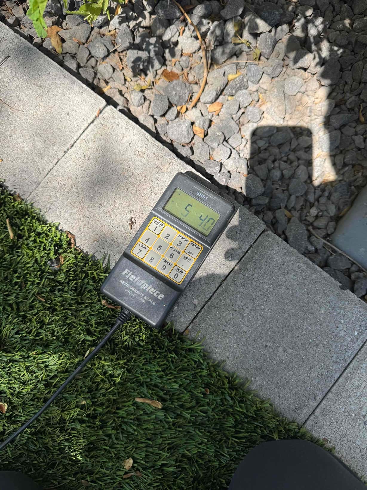 Refrigerant scale photographed during the service visit; no numerical reading is transcribed.