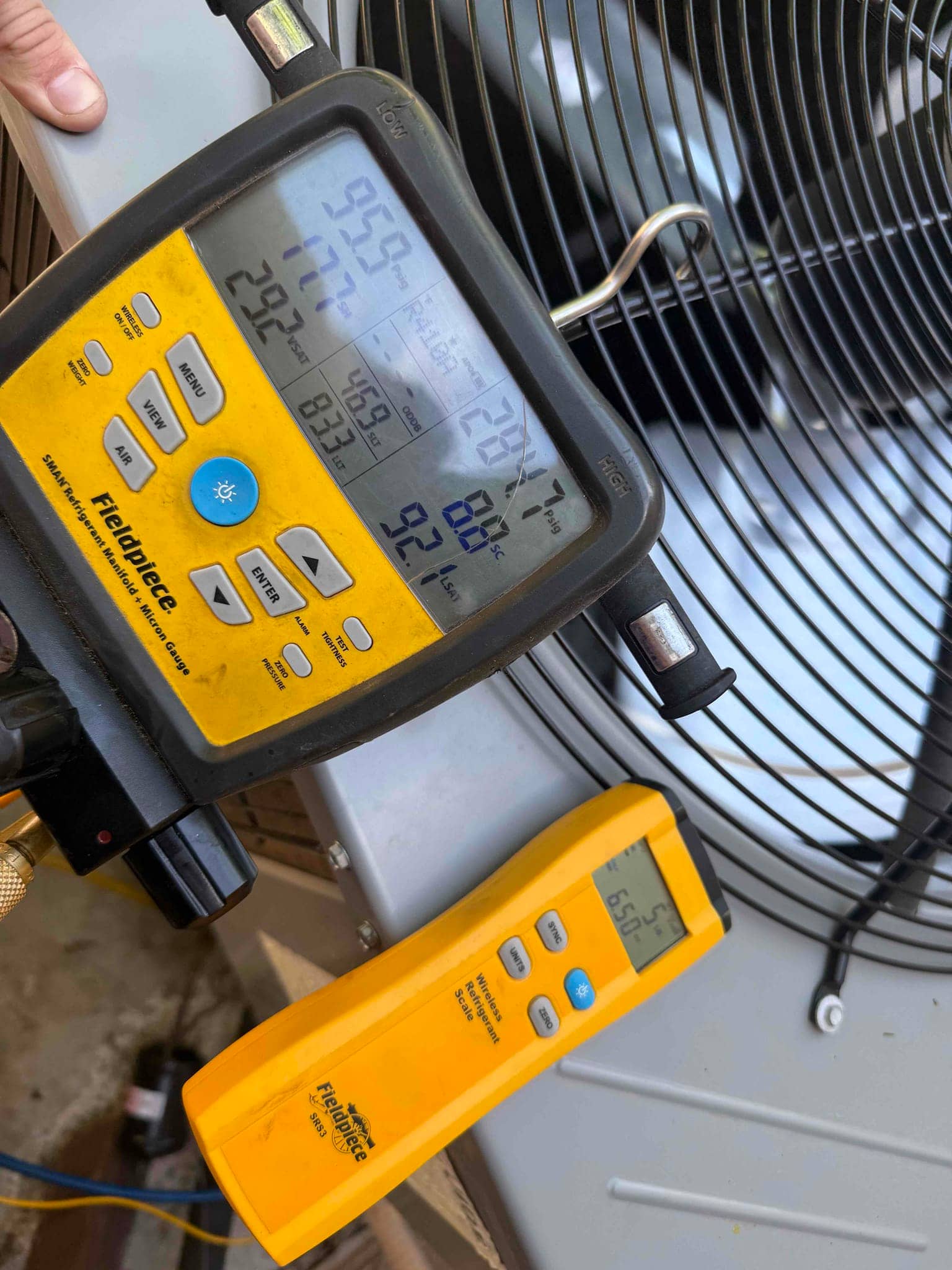 Refrigerant scale photographed during the service visit; no numerical reading is transcribed.
