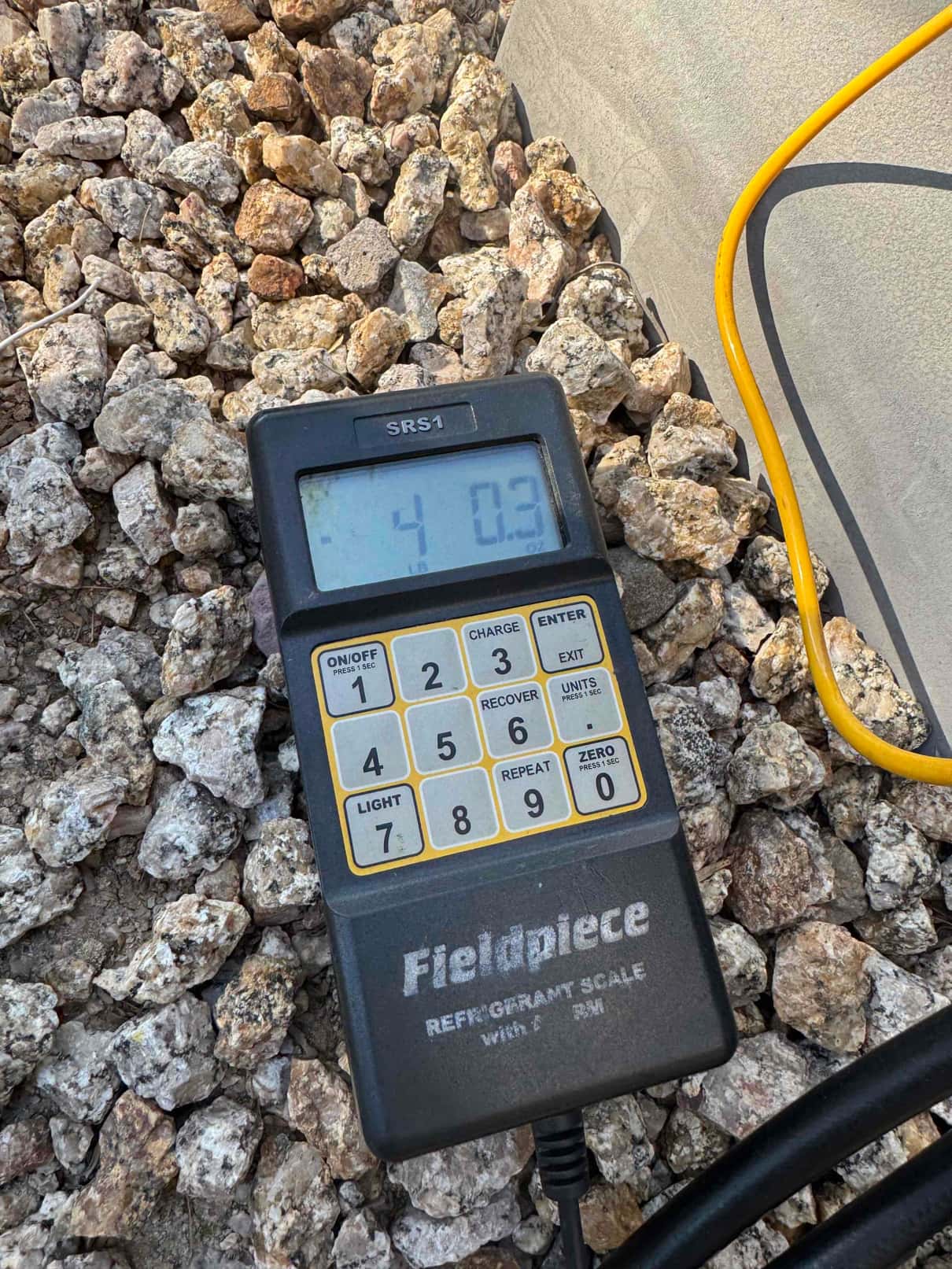 Refrigerant scale photographed during the service visit; no numerical reading is transcribed.