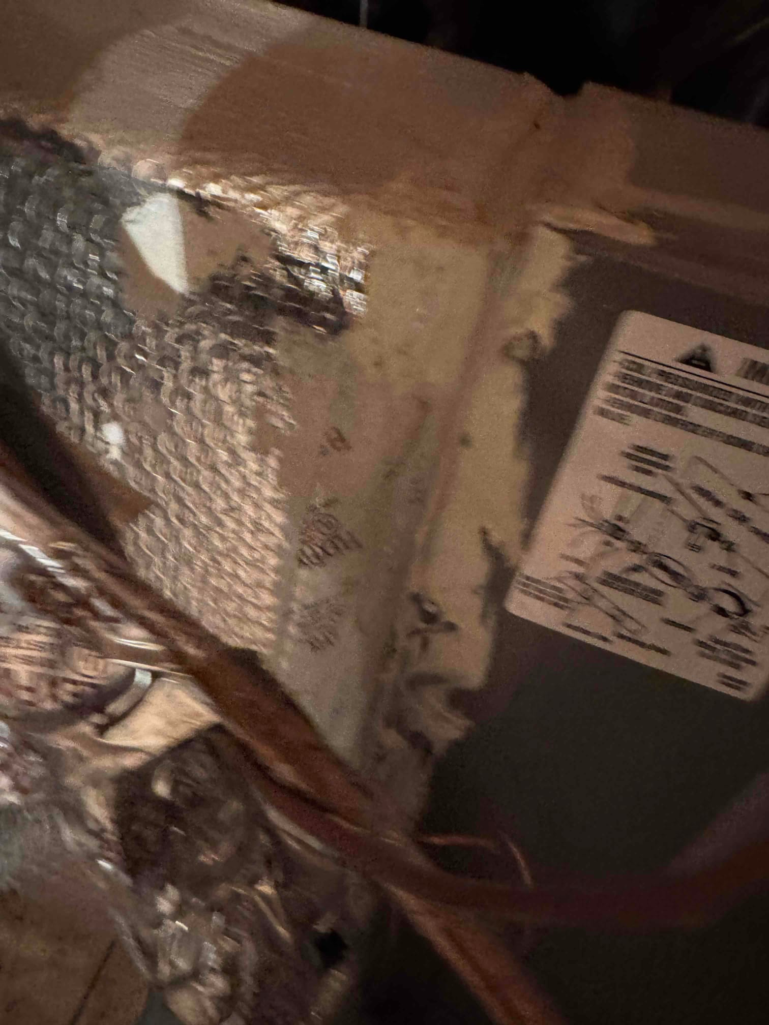 Sheet-metal housing with foil-faced insulation and mastic at a seam; equipment diagram label on side.