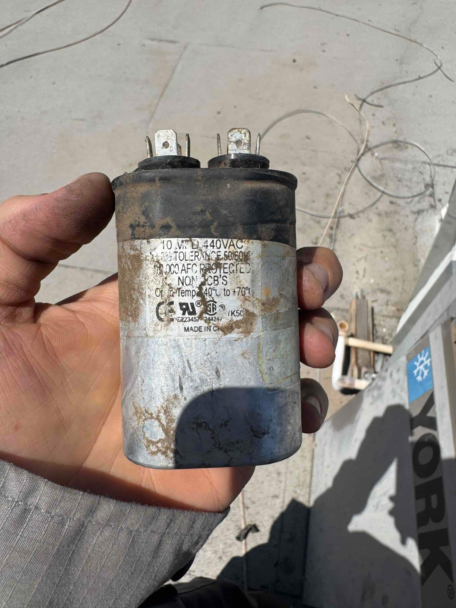Single run capacitor with two terminals and printed rating 440 VAC on its label.