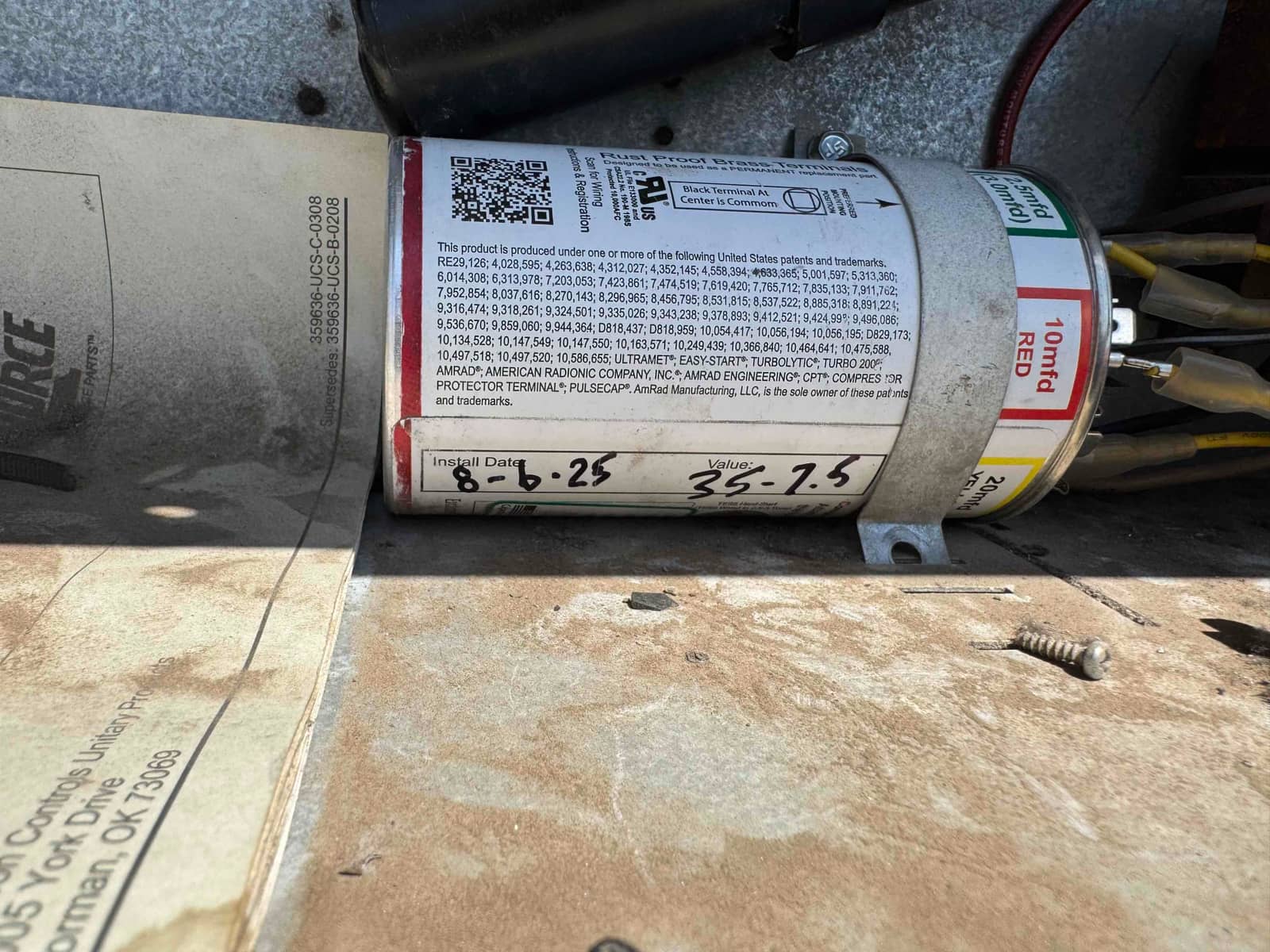 Universal dual-run capacitor with color-coded terminals and attached wiring, marked Install Date 8-6-25 and Value 35-7.5 on the label.