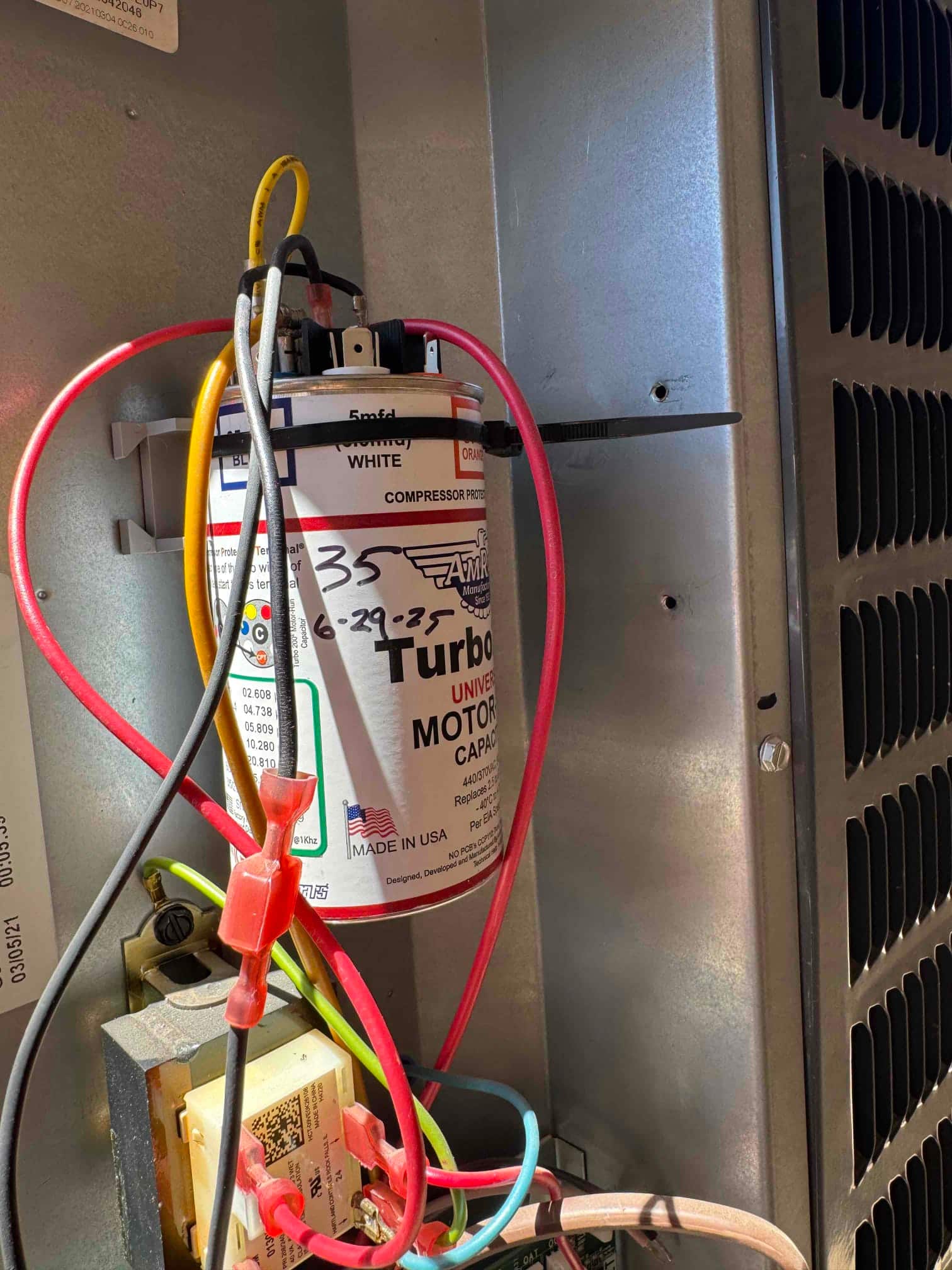 Universal motor run capacitor installed in the control compartment with red, yellow, and black leads connected; top label shows 5 mfd.