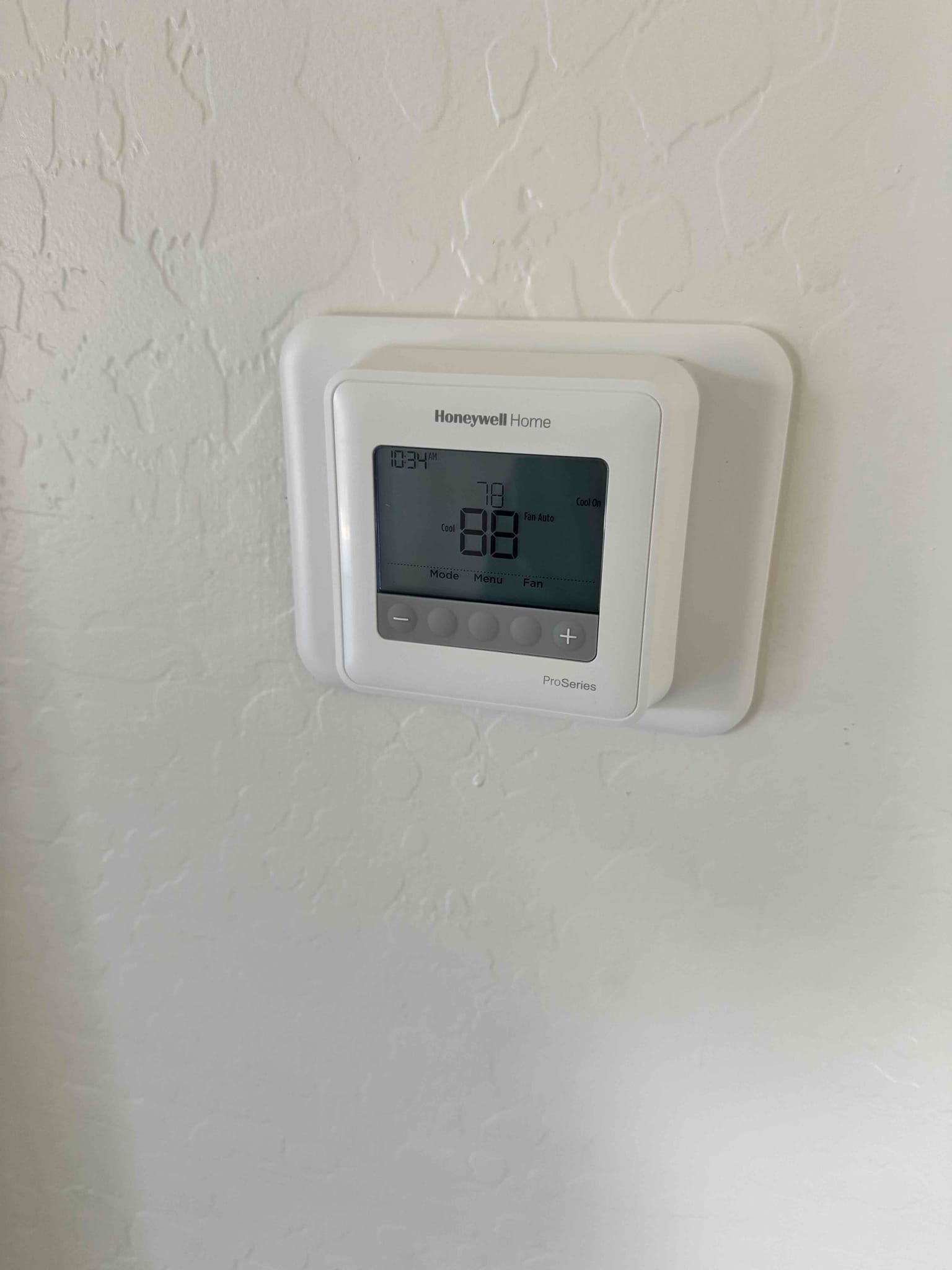 Wall-mounted digital thermostat in cooling mode, display shows setpoint 78 with fan set to Auto.
