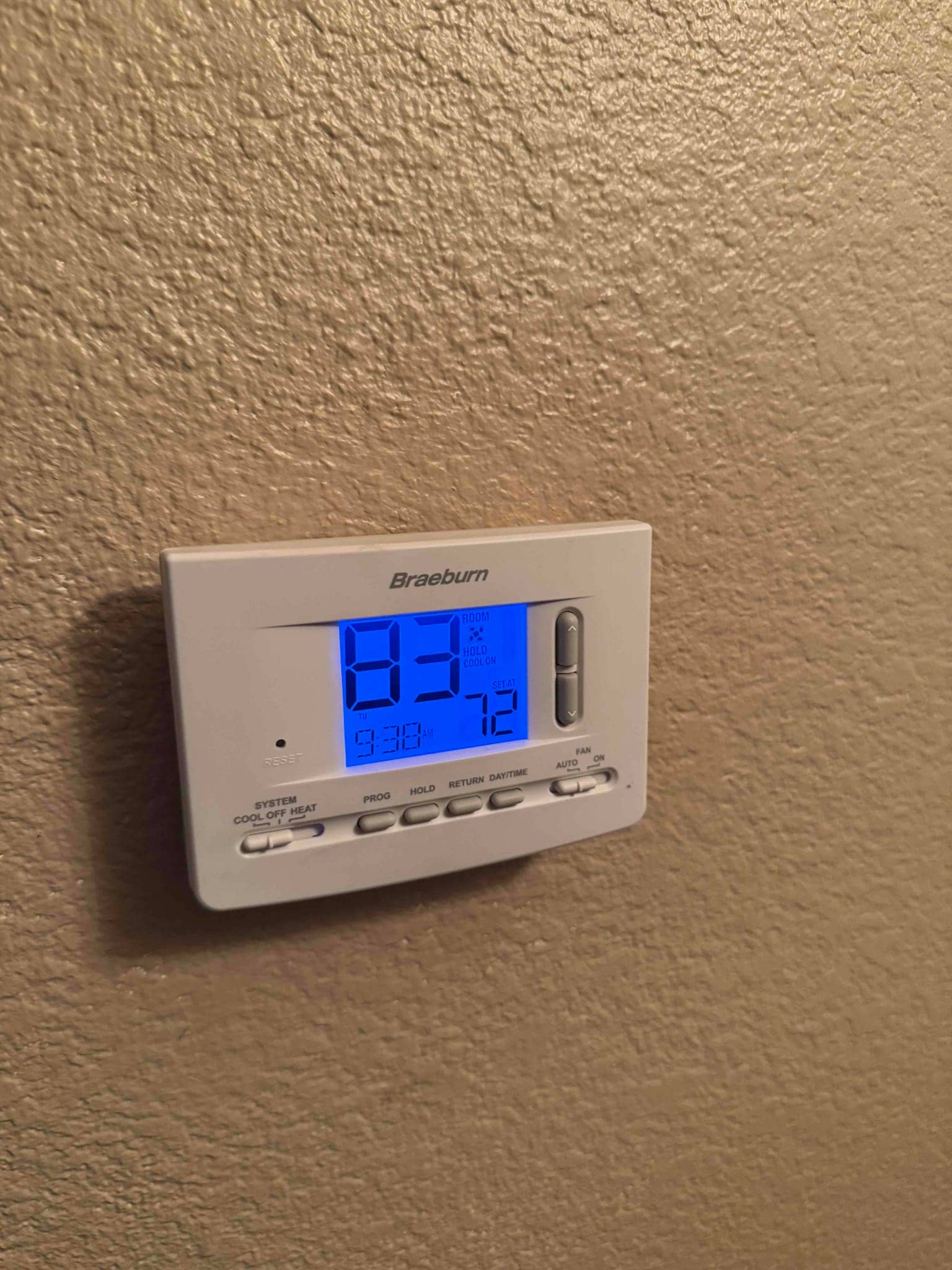 Wall-mounted digital thermostat displays room temperature 83°F and setpoint 72°F with system cooling selected.
