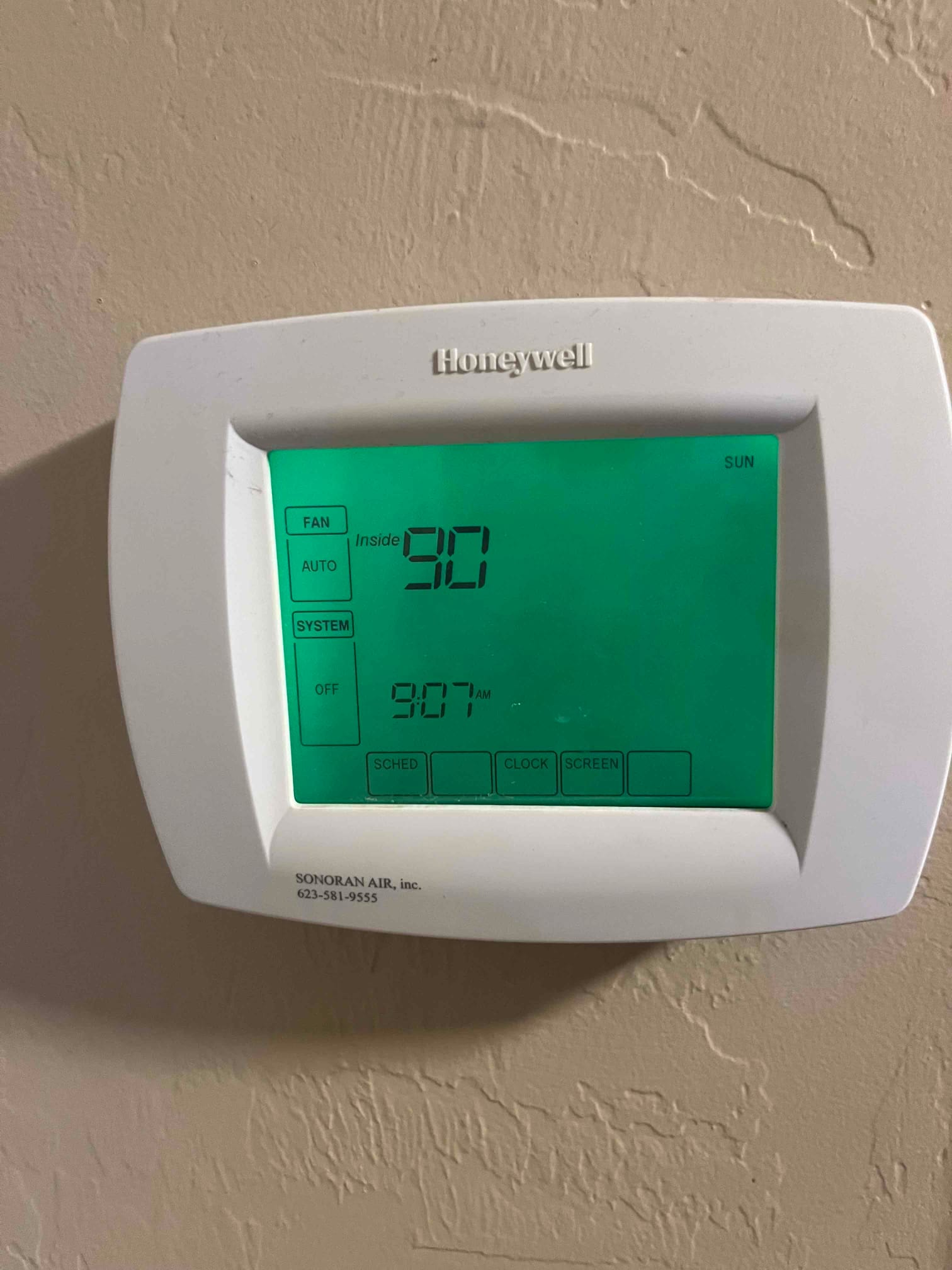 Wall-mounted digital thermostat showing Inside 90 with fan set to Auto and system Off.