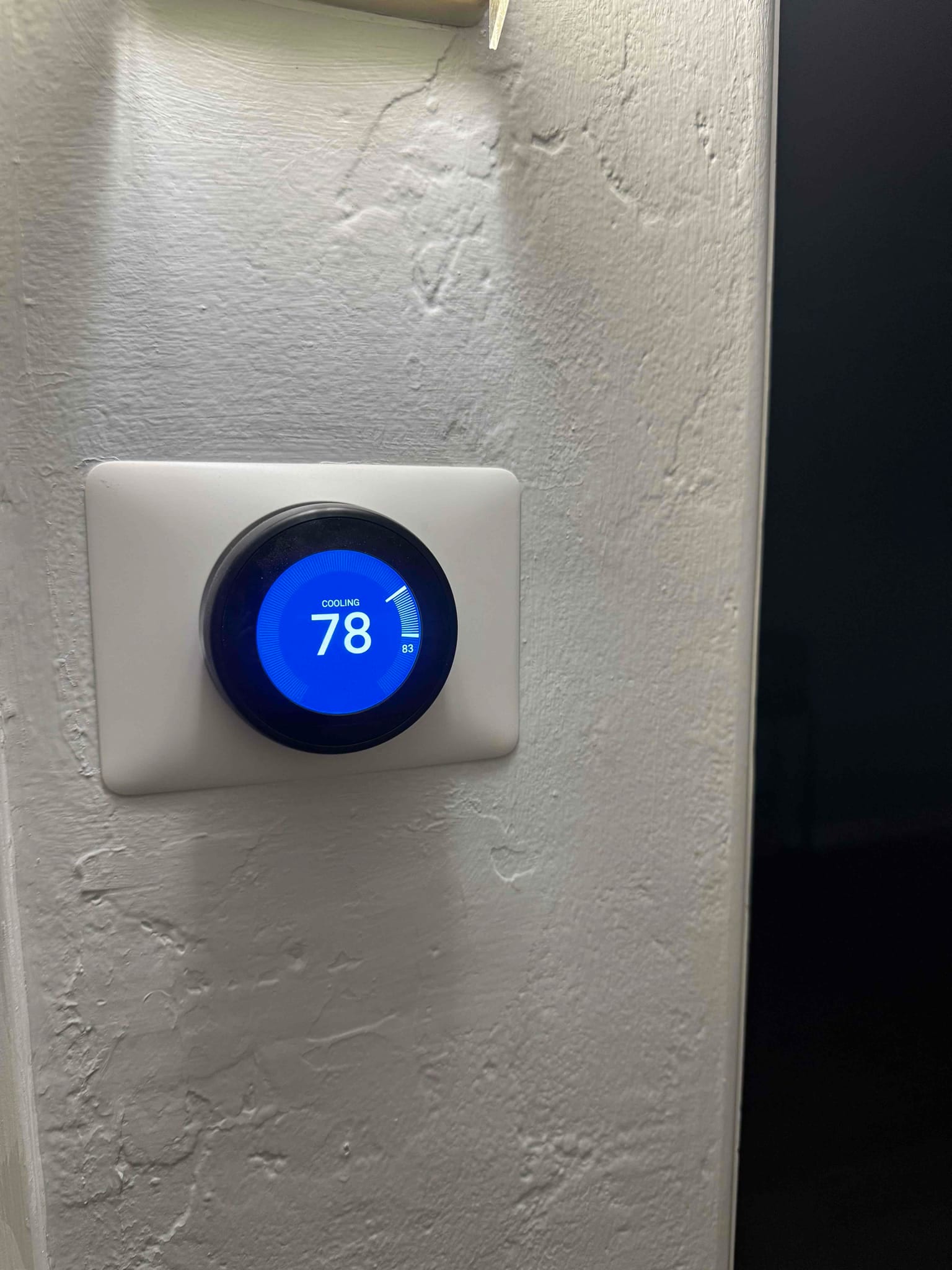 Wall-mounted smart thermostat display shows cooling mode with setpoint at 78 degrees.