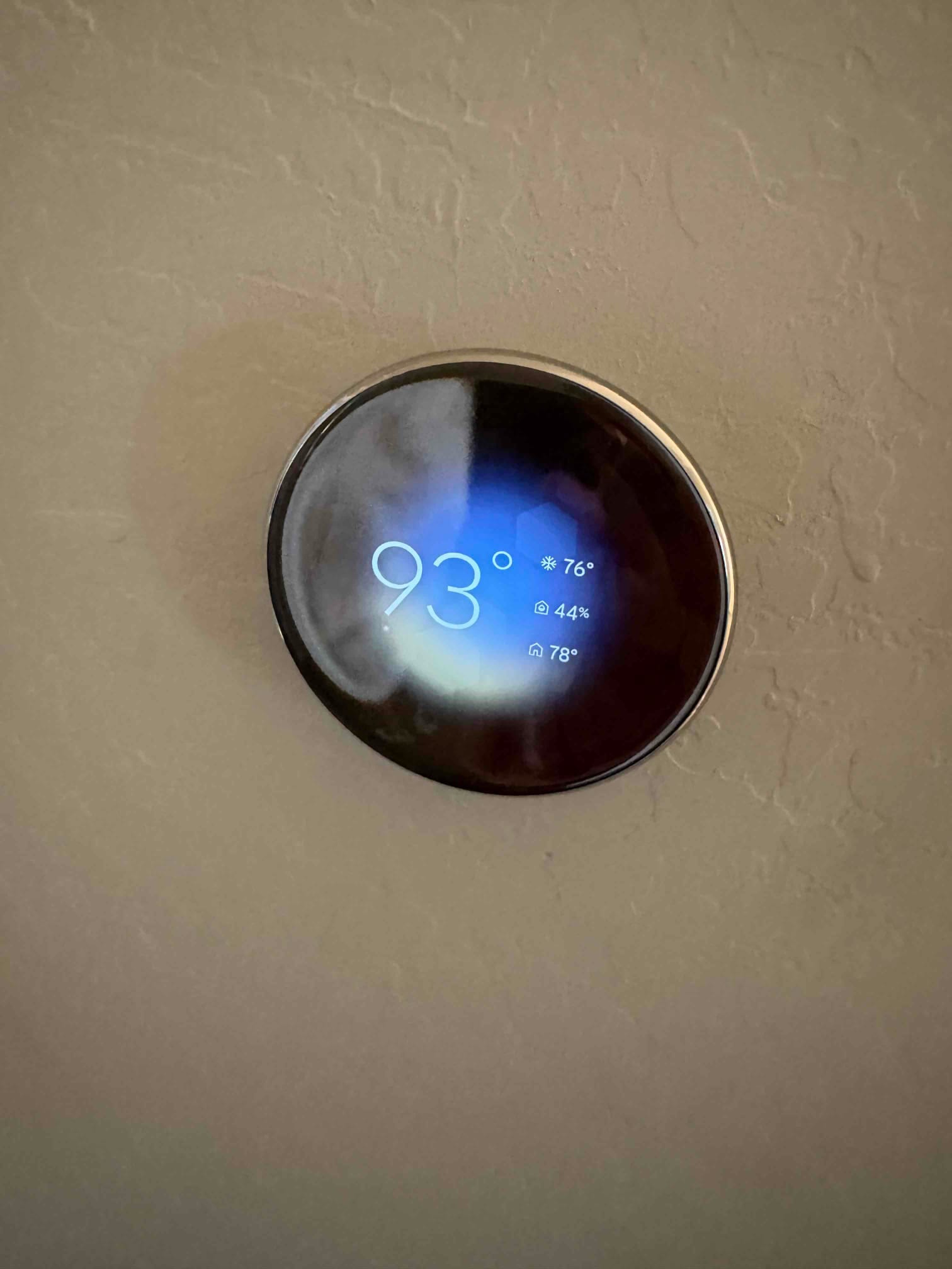 Wall-mounted smart thermostat displays 93° with cooling icon, additional indicators showing 76°, 44% humidity, and 78°.