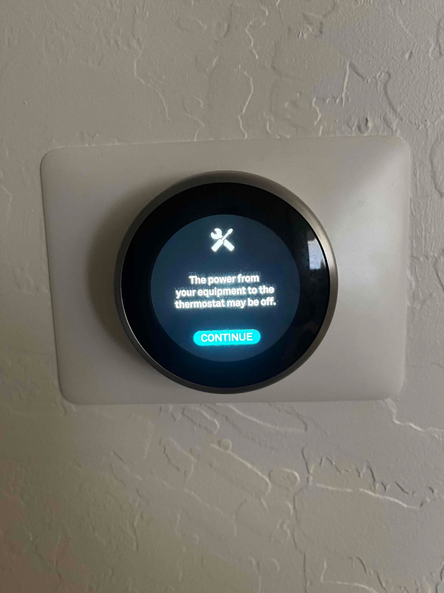 Wall-mounted smart thermostat displays an alert stating power from the equipment to the thermostat may be off.