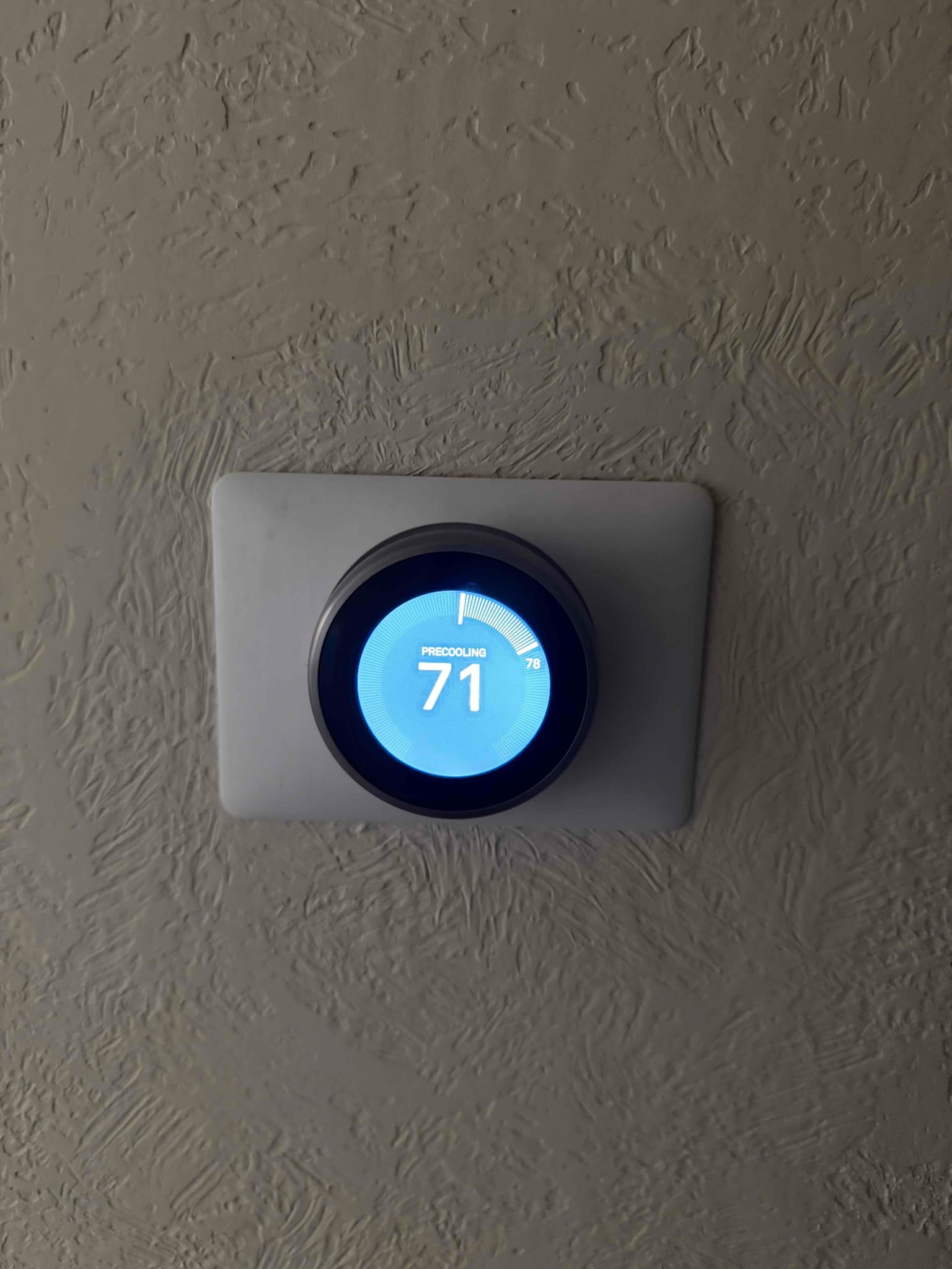 Wall-mounted smart thermostat shows PRECOOLING with the set temperature at 71 and circular progress indicator.