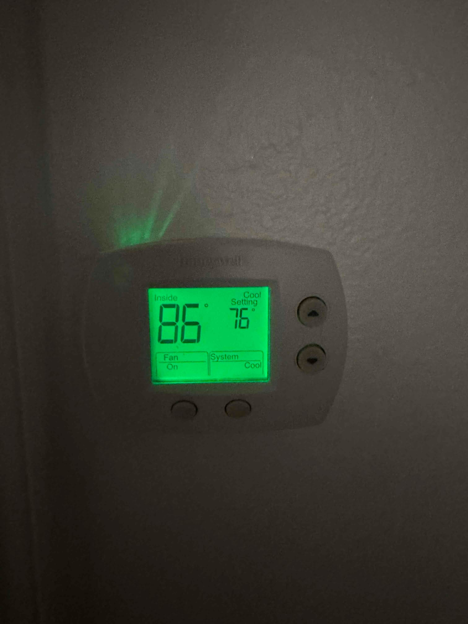 Wall-mounted thermostat displays inside 86 and cool setting 76, with fan on and system cooling.