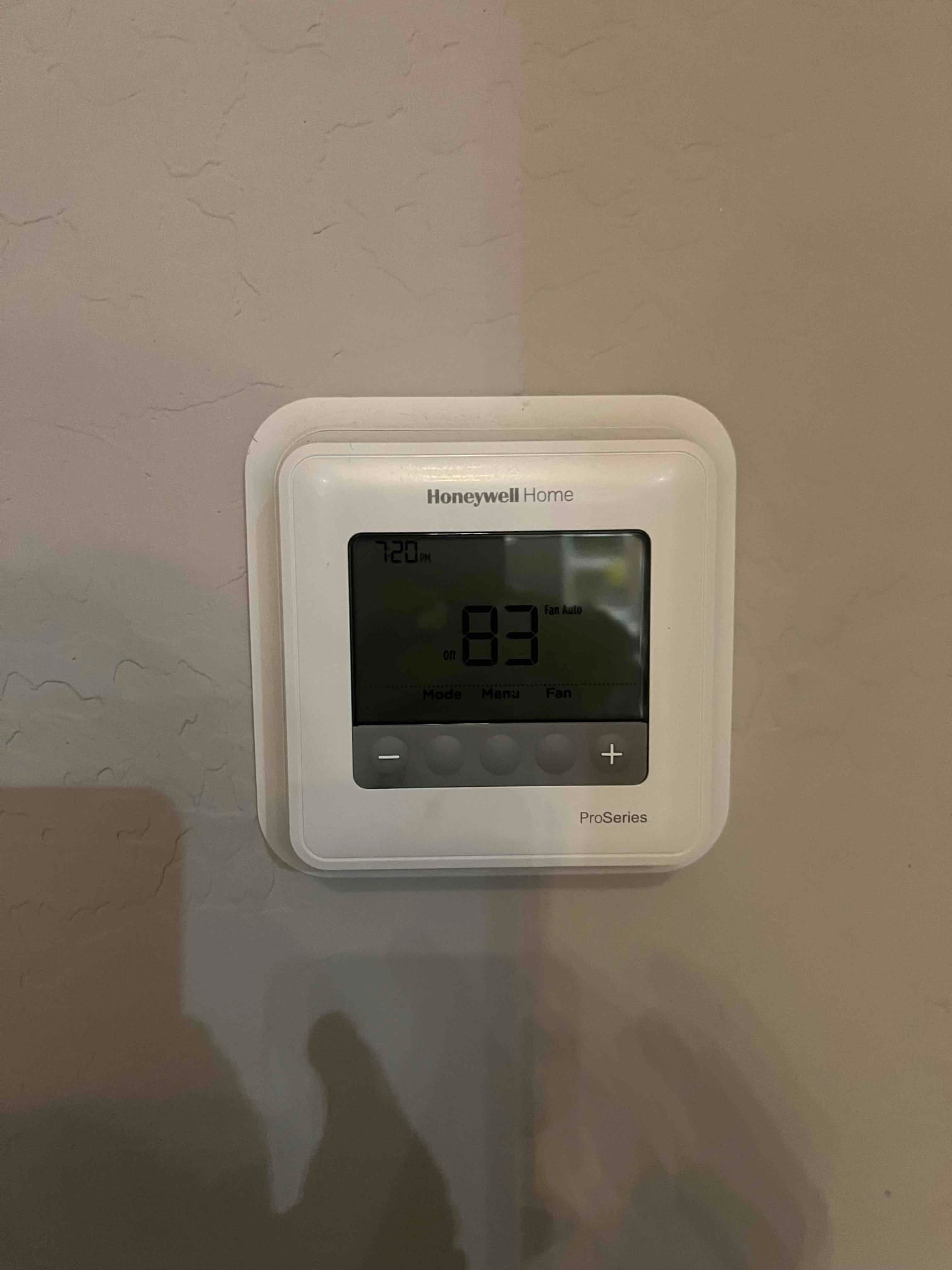 Wall-mounted thermostat shows 83 with system off and fan set to auto.