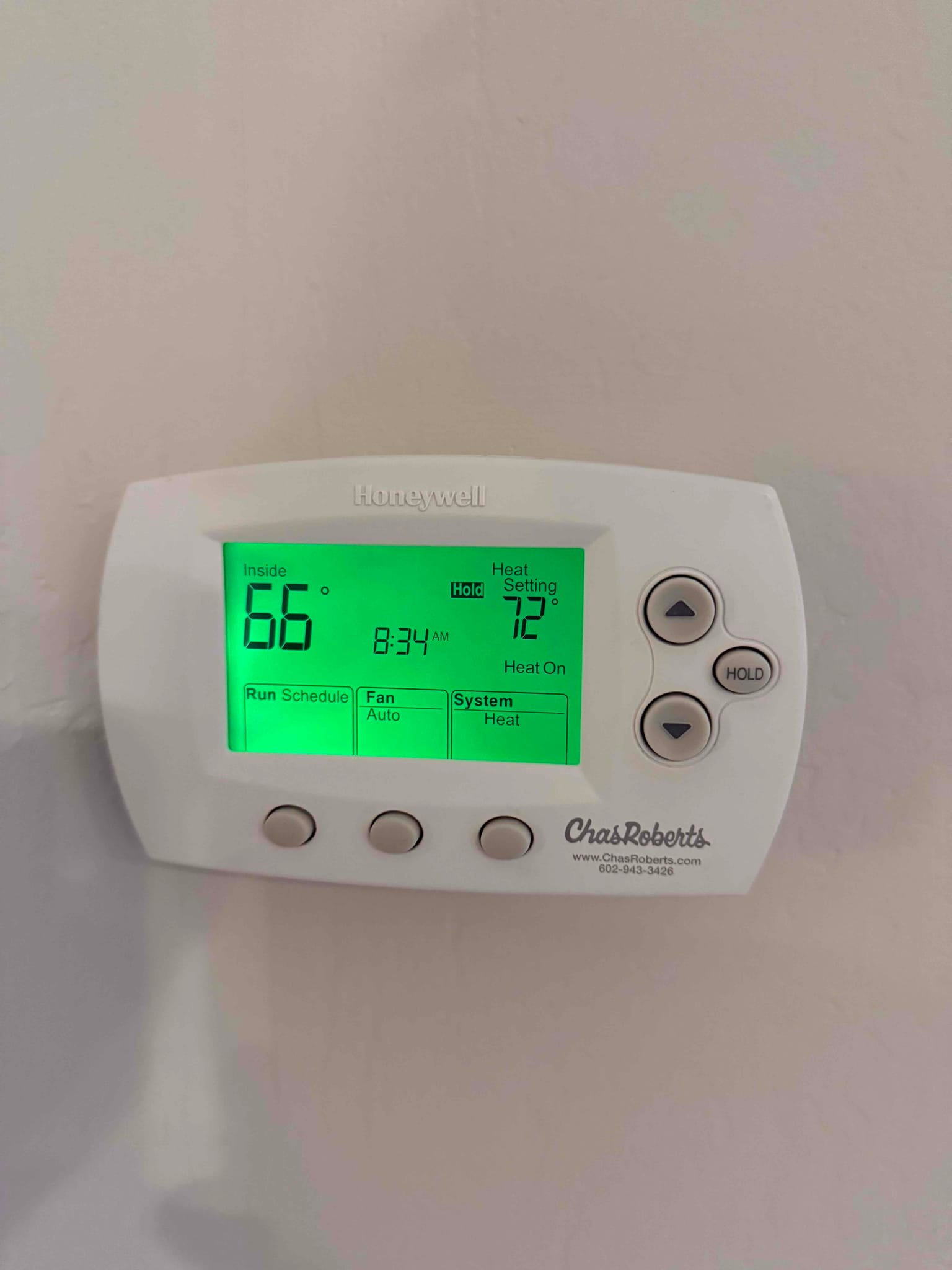 Wall-mounted thermostat shows inside 66°F, heat set to 72°F, system heat on with fan auto.