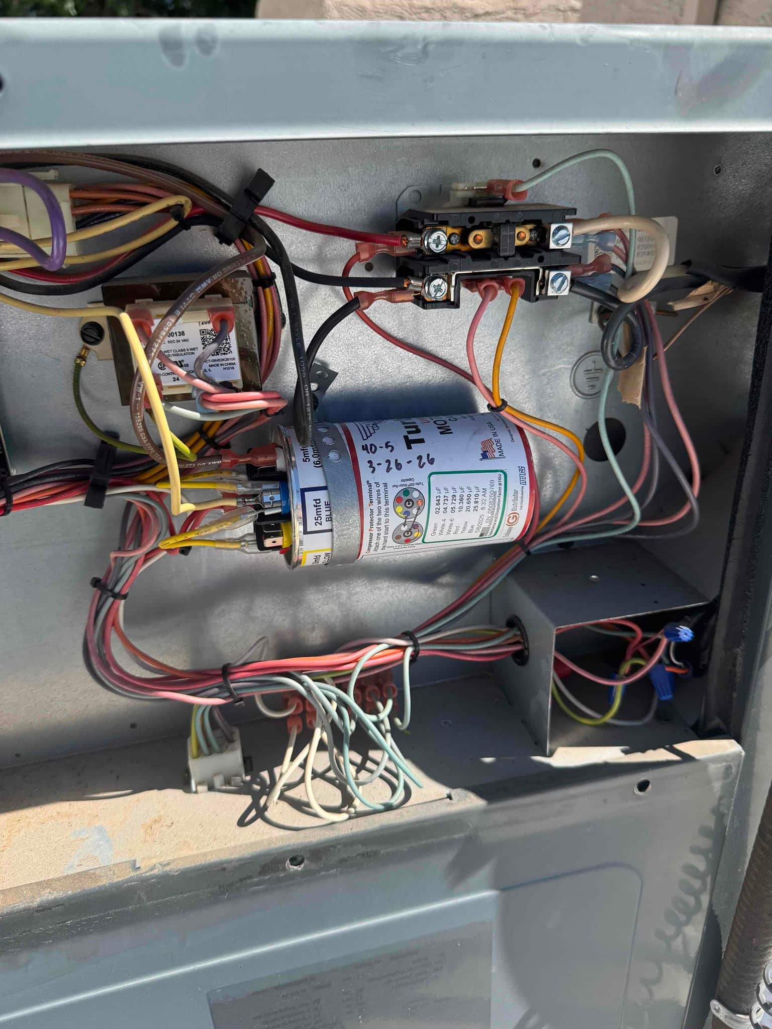 Condenser control compartment showing dual-run capacitor labeled 40/5 μF, a two-pole contactor, wiring harnesses, and bundled low‑voltage wires.