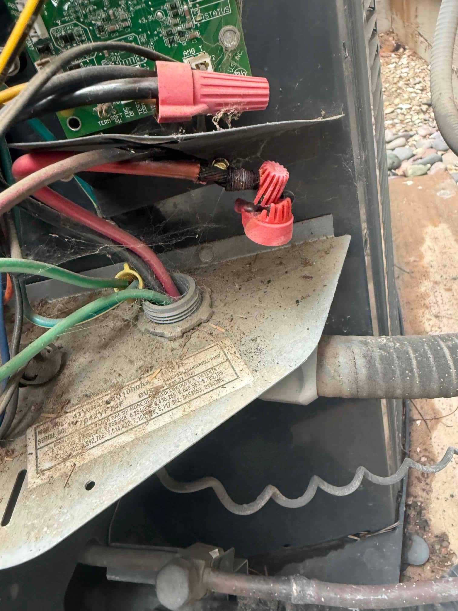 Control panel wiring with red wire connectors; one connection shows melted insulation and a deformed wire nut.
