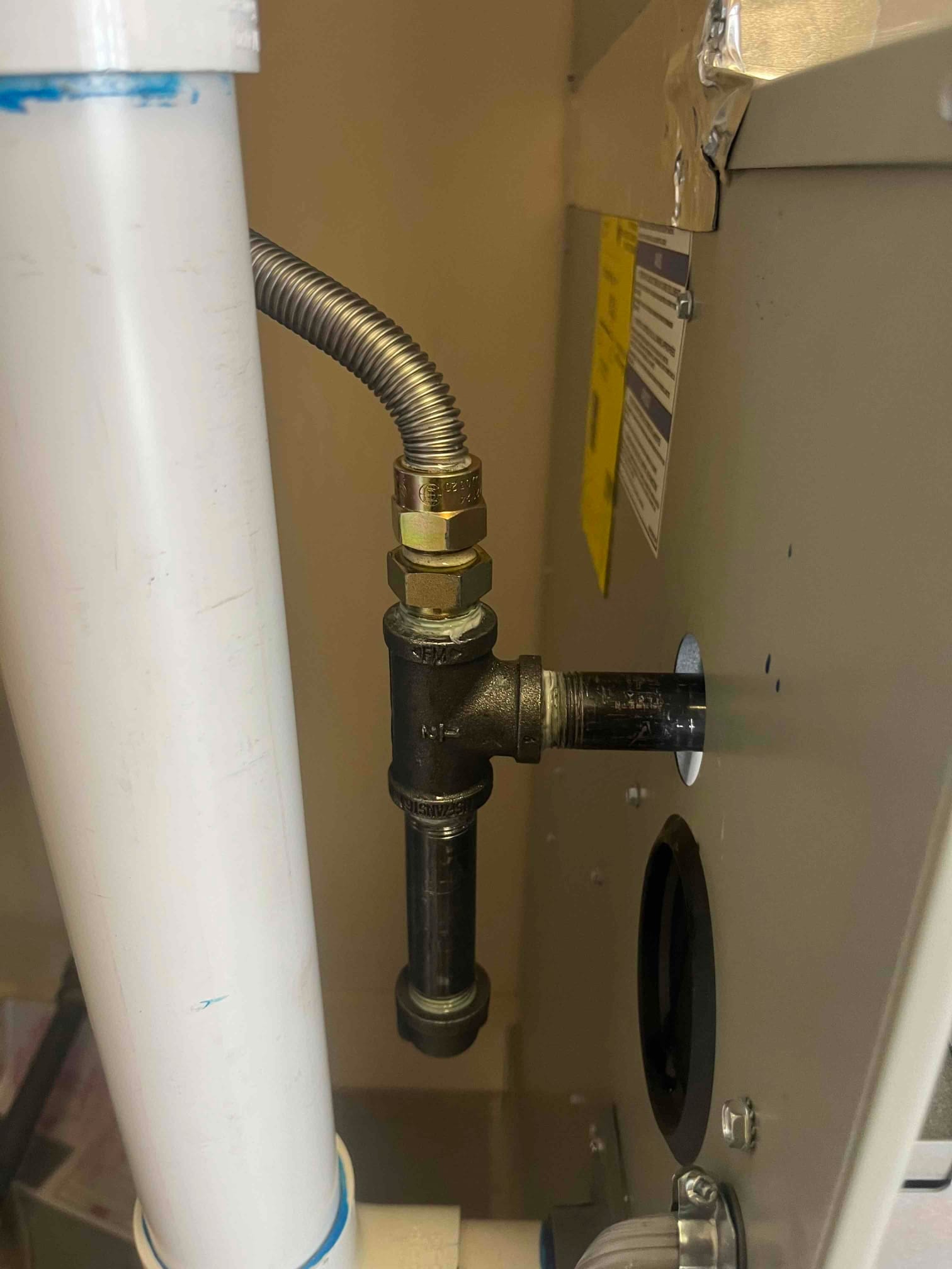 Gas supply connection at furnace with flexible connector, tee fitting, and vertical sediment trap drip leg.