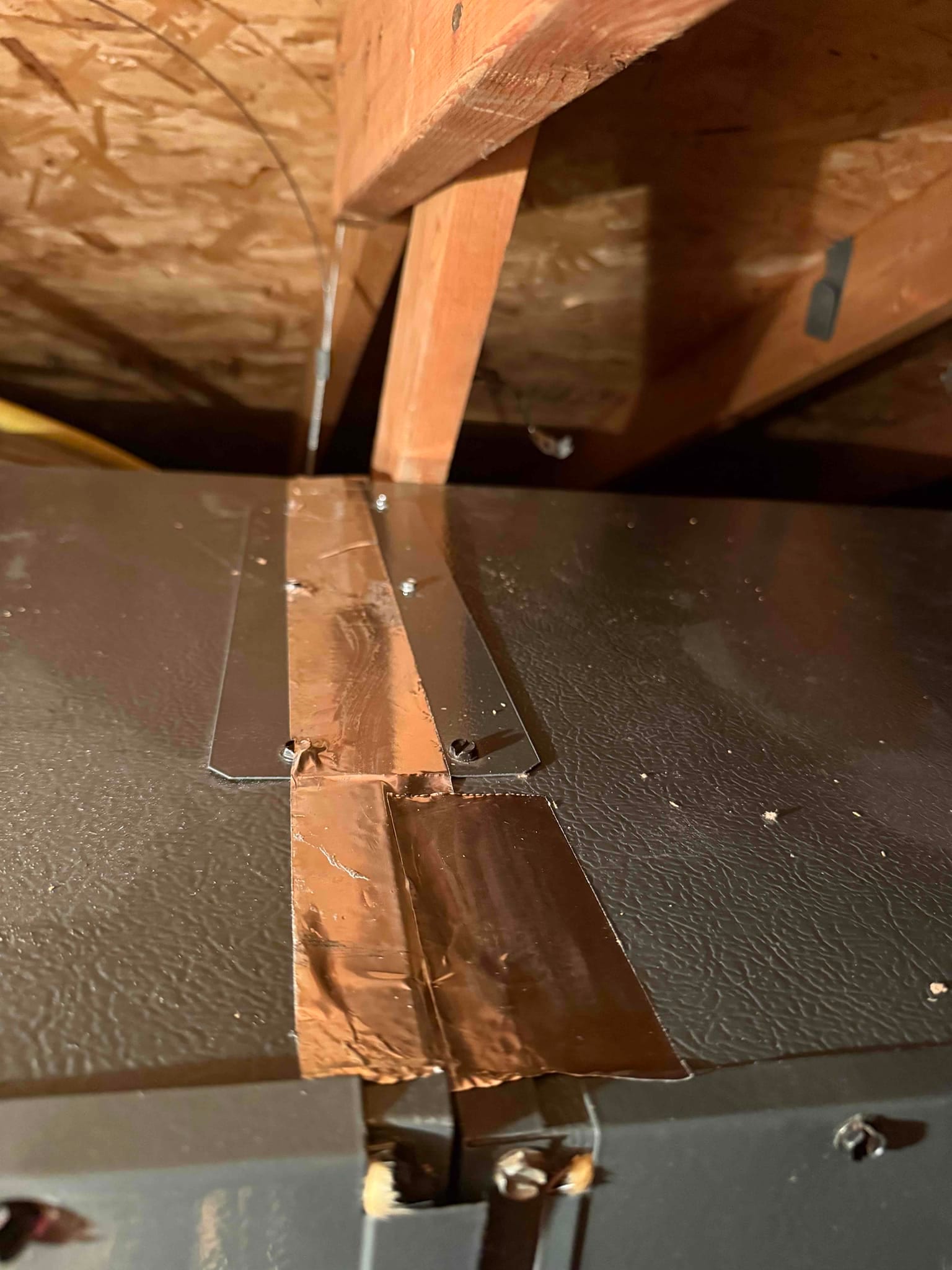 HVAC cabinet top with foil tape applied along the center seam and corner.