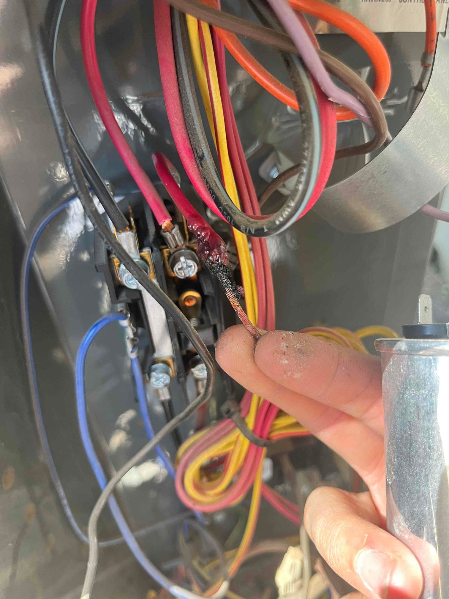 HVAC electrical compartment shows a disconnected conductor with burnt insulation near the contactor, while a technician holds a run capacitor.