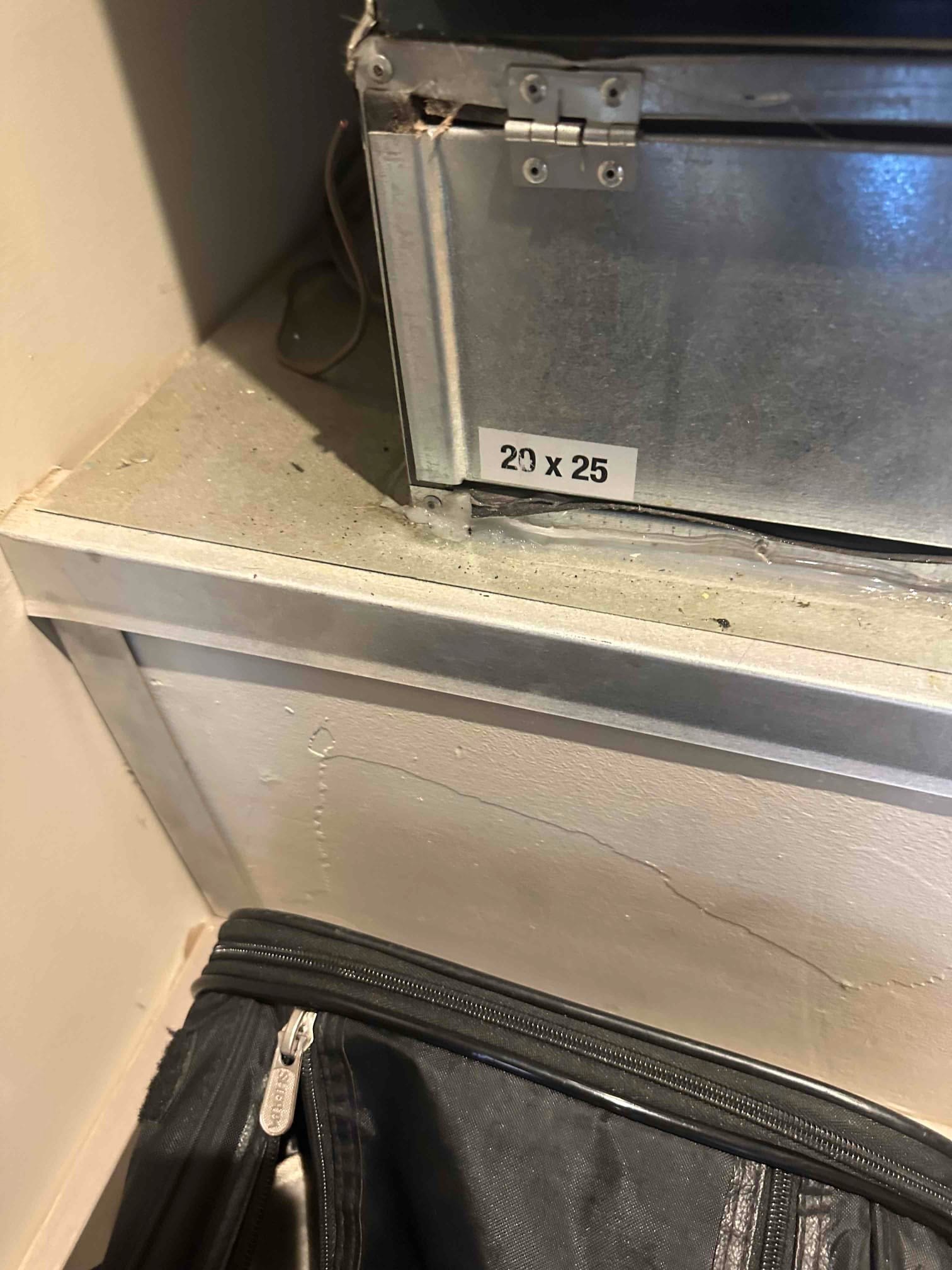 Metal return air filter cabinet with hinged access panel and sticker showing 20 x 25 filter size.