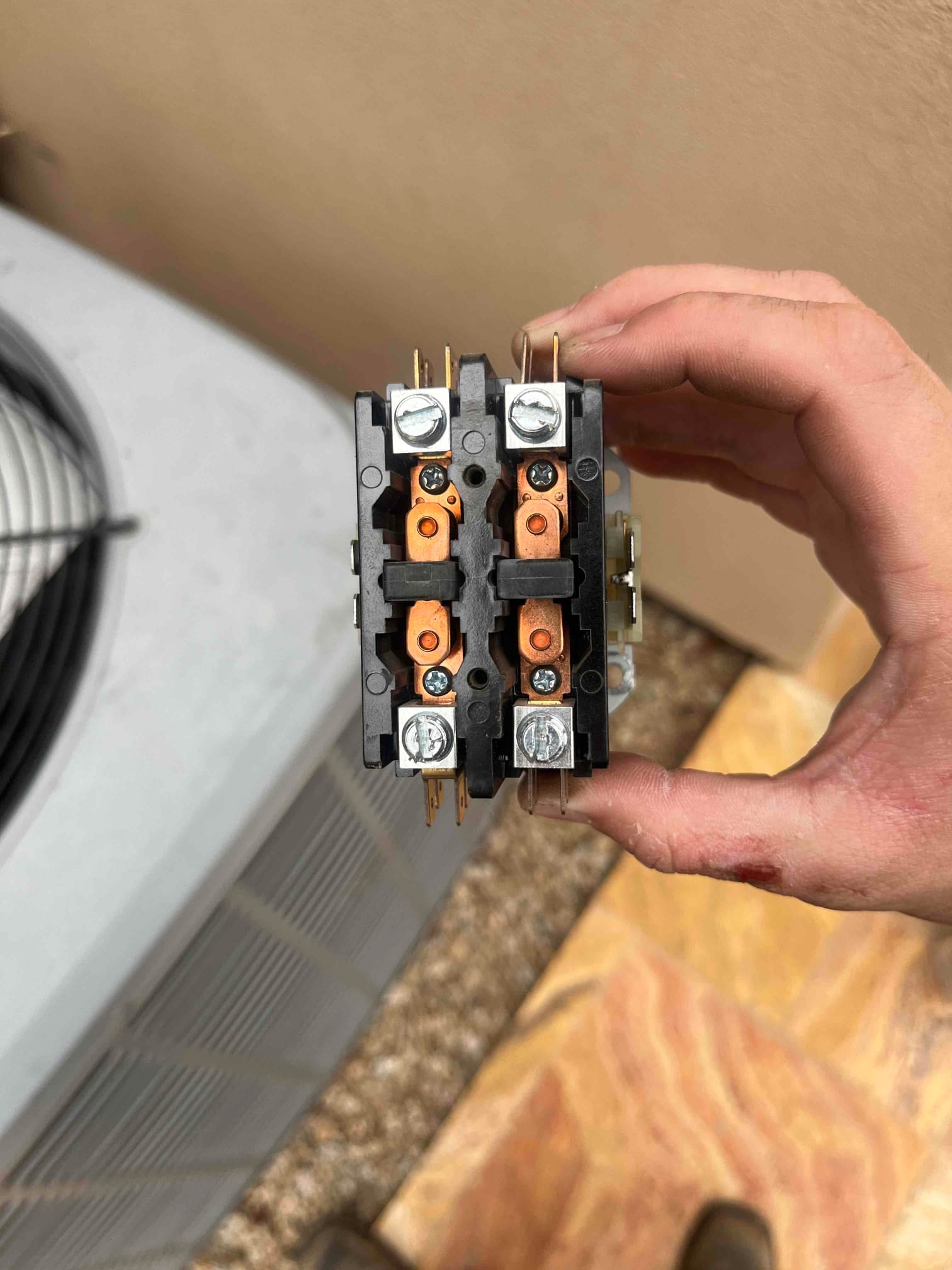 Two-pole contactor with screw lugs and copper contacts, shown by the outdoor condenser unit.