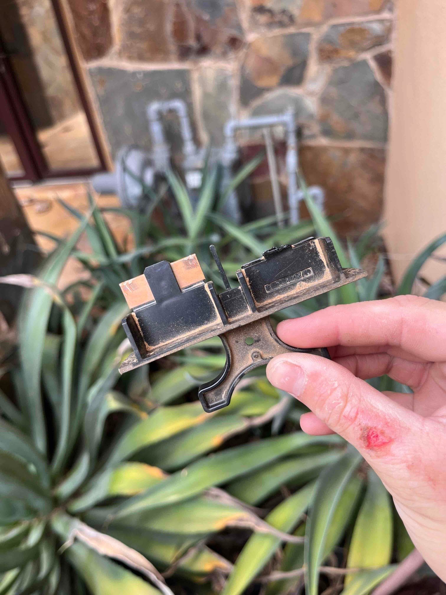Pull-out fused disconnect handle with two metal blades, removed and shown close-up outdoors during service.