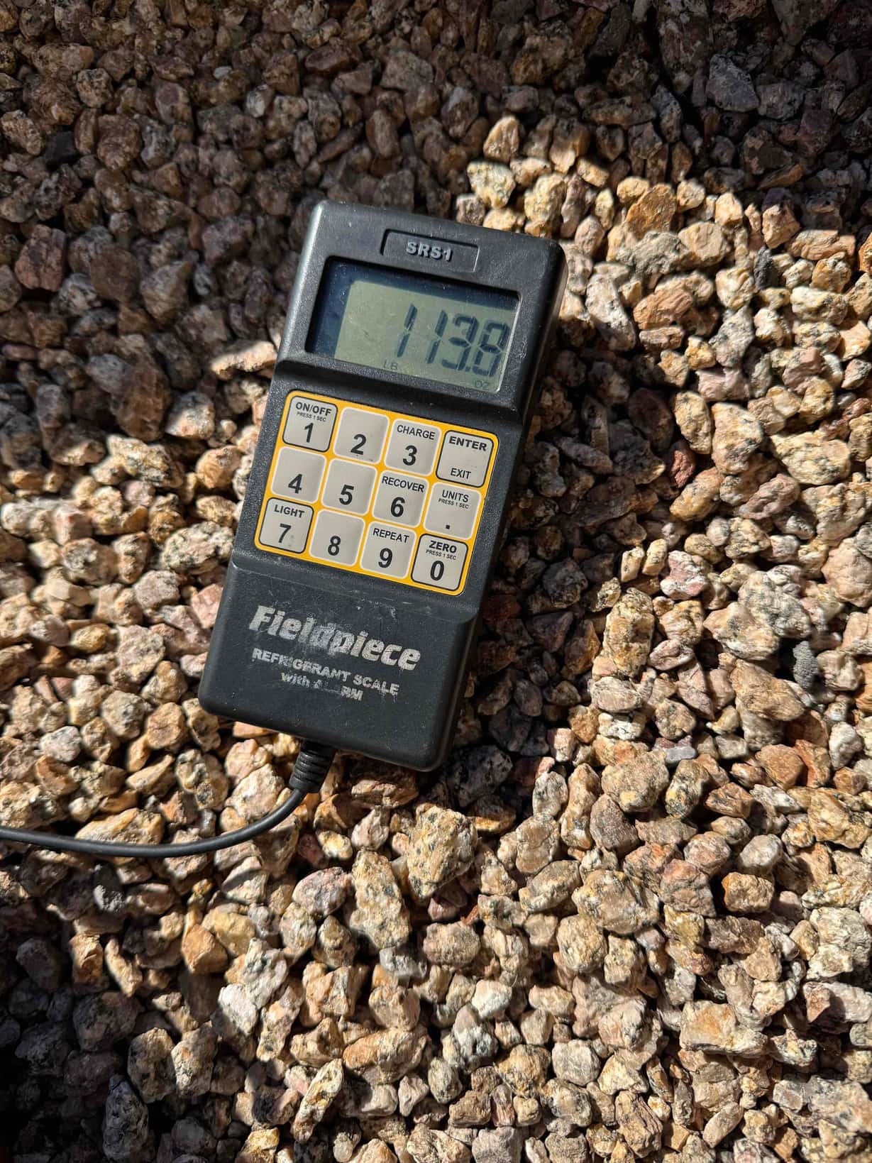 Refrigerant scale photographed during the service visit; no numerical reading is transcribed.